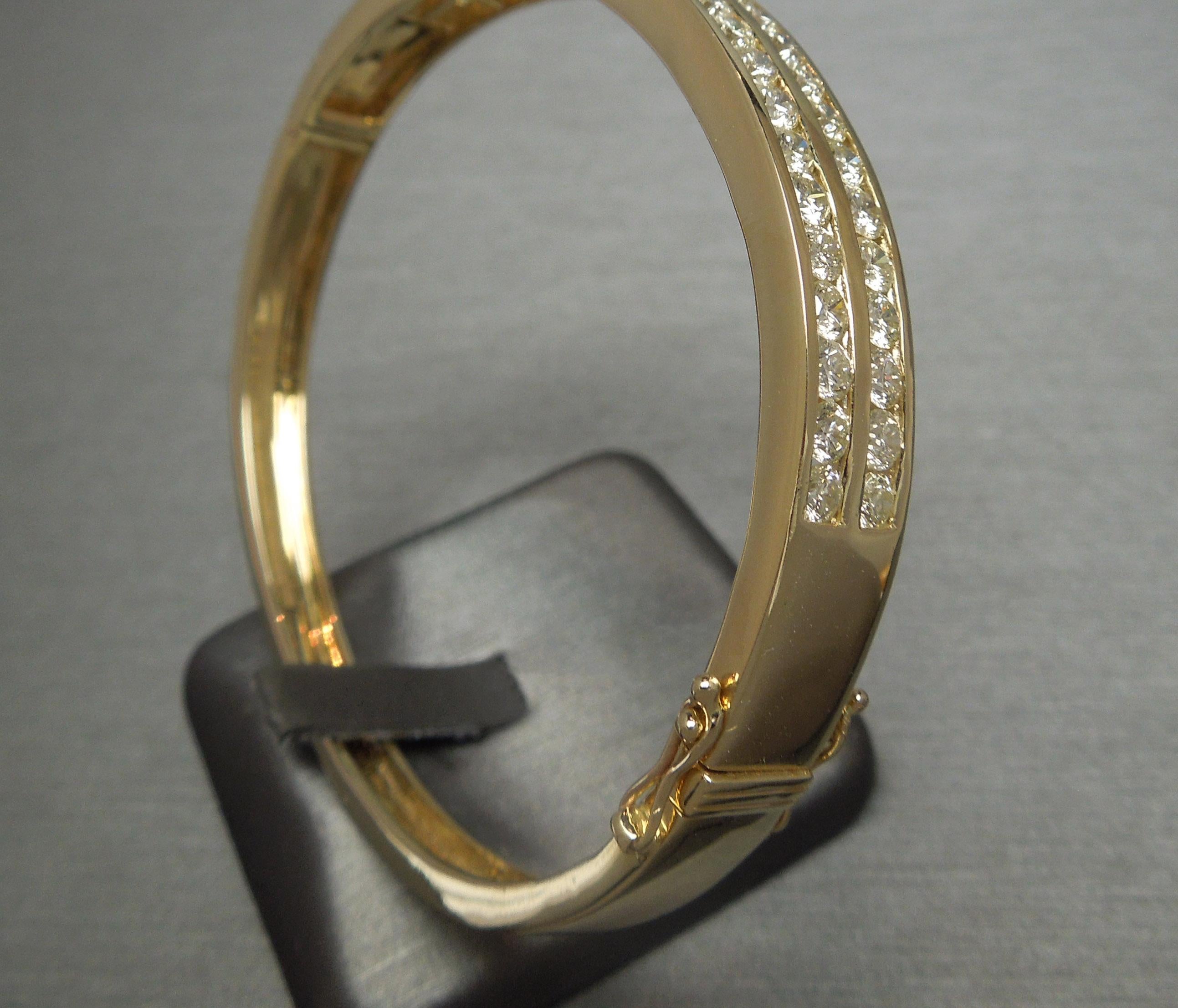 This 14 Karat Yellow Gold Diamond Bangle Bracelet features 44 Nearly Flawless to Slightly Included Round Brilliant cut Diamonds totaling 5 carats ranking a J-K Color & VVS2-SI2 Clarity Channel set in a Double Row timeless, geometric design .. [Most