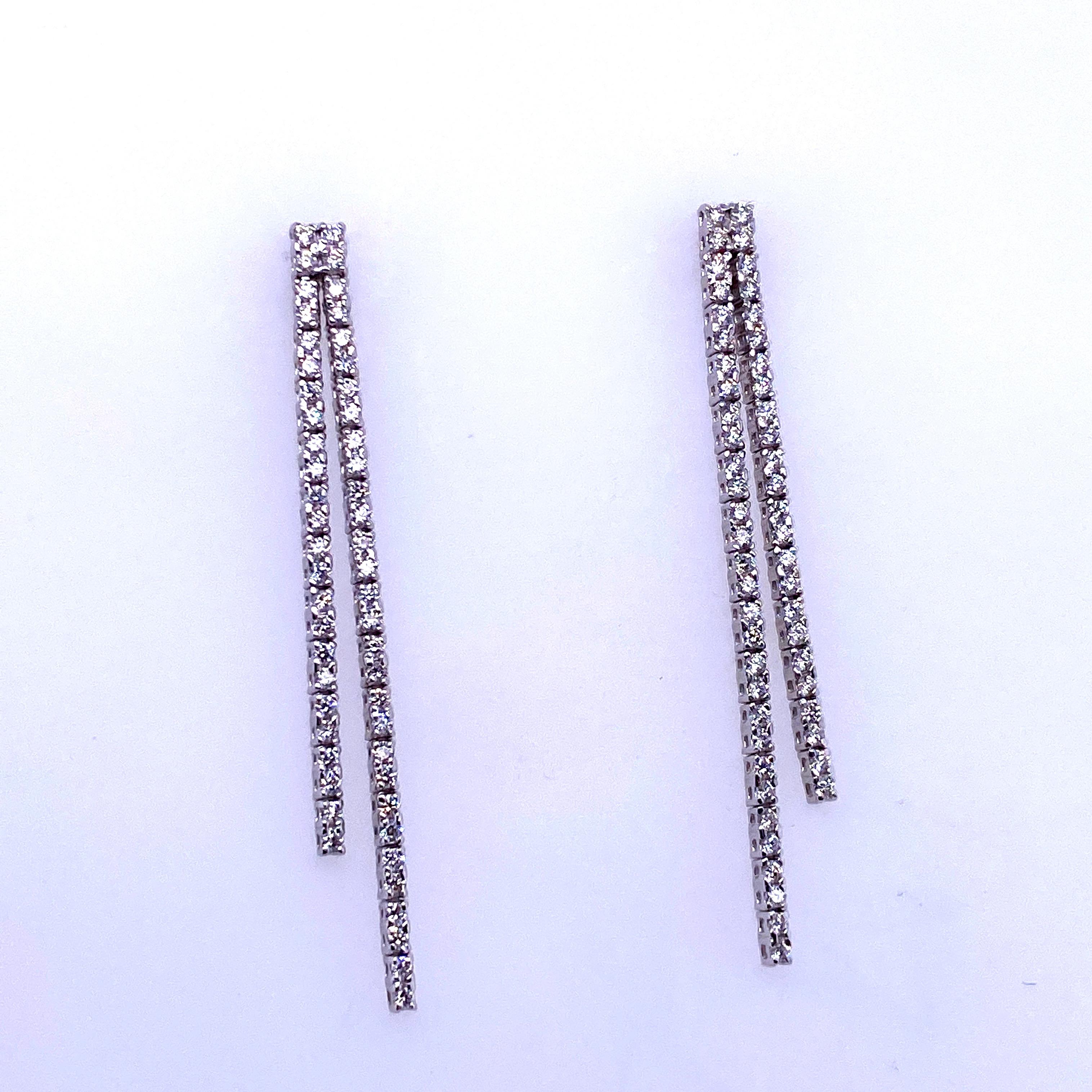 14K White gold drop earrings featuring two diamond rows containing 108 round brilliants weighing 0.90 carats. 
Color G
Clarity SI2

Available in yellow gold. 