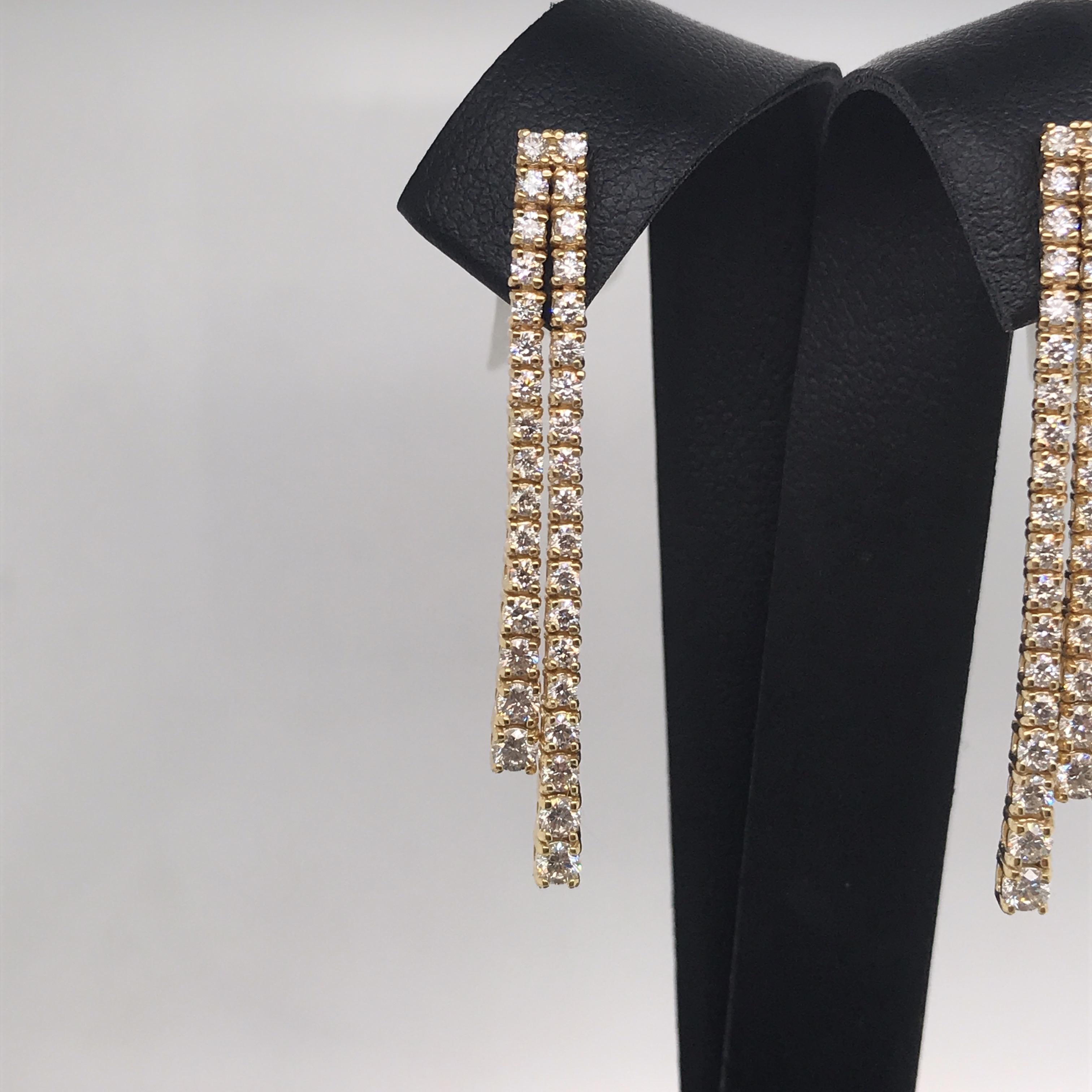 14K Yellow gold drop earrings featuring two diamond rows containing 70 round brilliants weighing 1.52 carats. 
Color G
Clarity SI2
Available in white gold. 