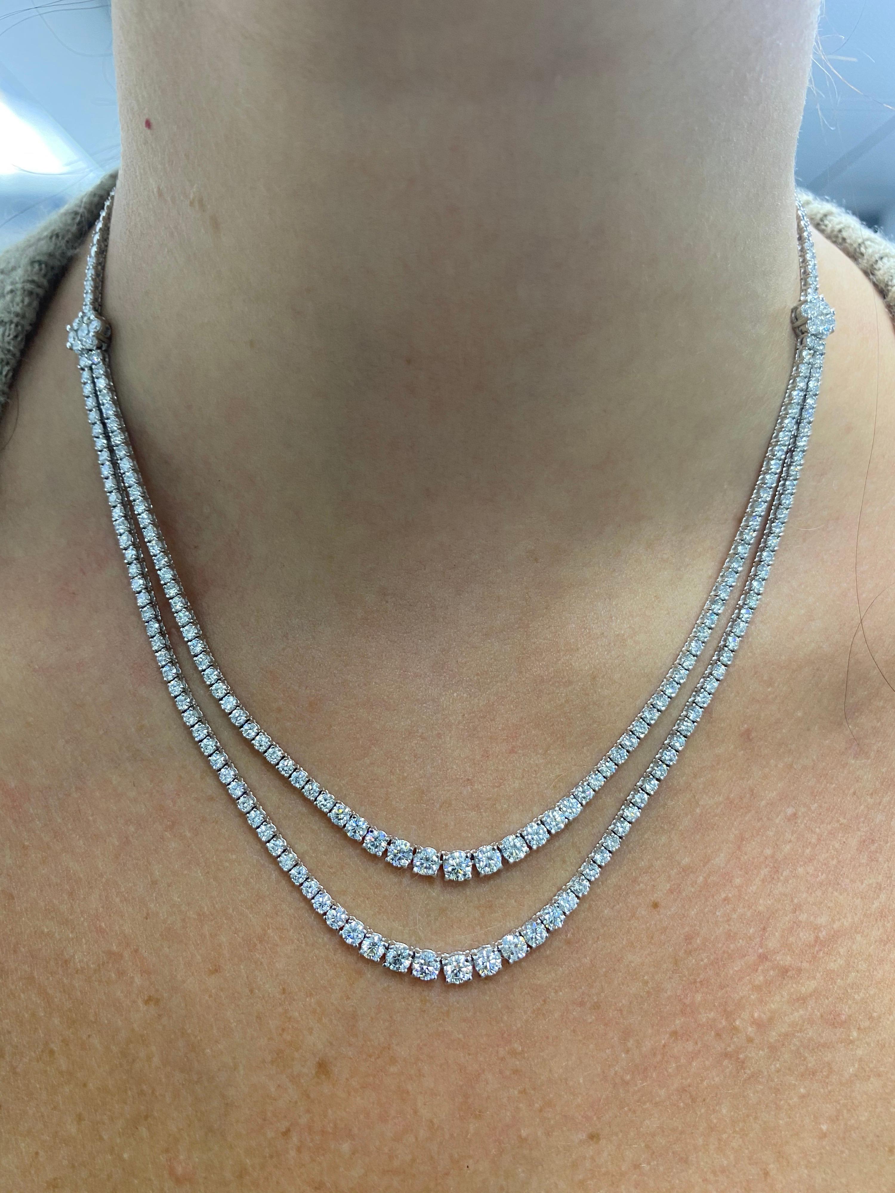 14K White Gold tennis necklace featuring a double diamond row of 182 round brilliants and two diamond clusters with 14 round brilliants weighing 9.33 carats and high polished white gold beads in the back. 
Color G
Clarity SI2
