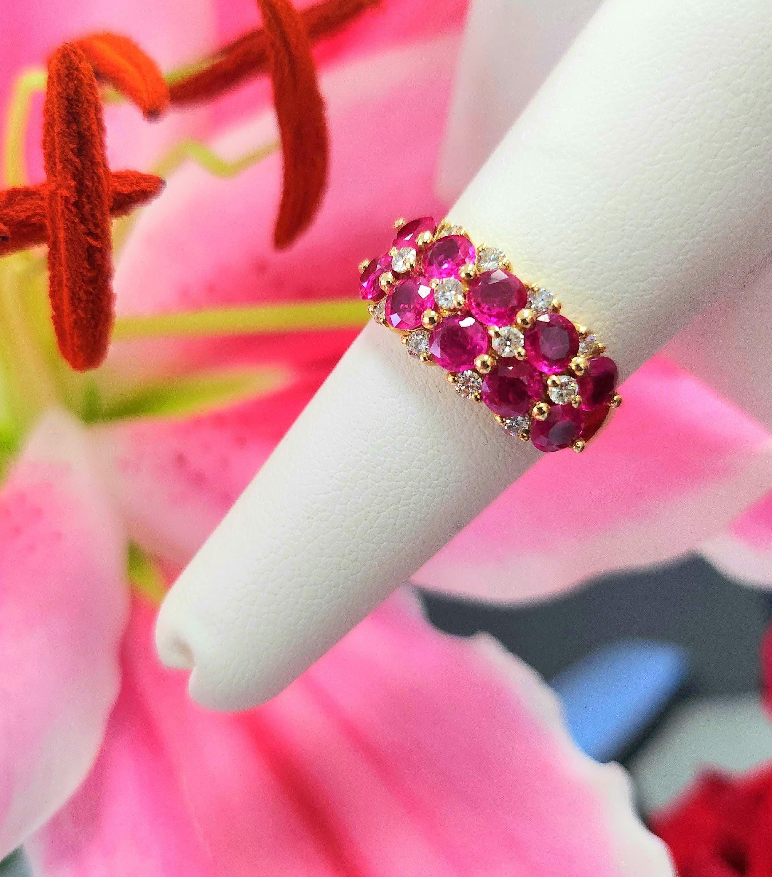 Dieser kühne und lebendige Ring aus 14-karätigem Gold besteht aus 10 lebhaften Rubinen (insgesamt 3,50 ct, je 4 mm) mit reichen rot-rosa Farbtönen, die von 12 runden Brillanten (~0,35 ct, F/G VS/SI) akzentuiert werden. Die skulpturale Galerie