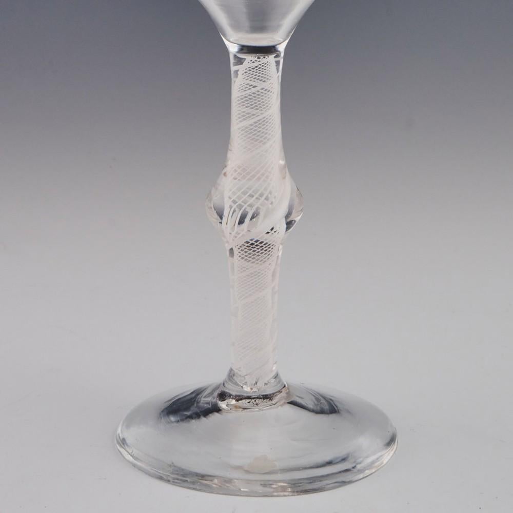 Heading : Opaque twist stem Georgian wine glass
Period : c1760
Origin : England
Colour : Clear
Bowl : Ogee with everted rim
Stem : A pair of spiral tapes outwith a multi spiral core
Foot : Conical
Pontil : Snapped
Glass Type : Lead
Size :  15.1cm