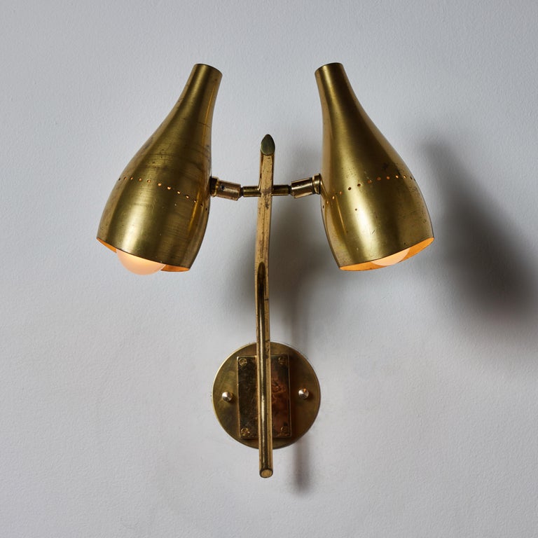 Double shade sconce by Lumen. Manufactured in Italy, circa 1950's. Brass, custom brass backplates. Wired for U.S. standards. Shades articulate in various positions. Lightbulbs not included. Suggested Lamping: 2 Qty 120V E27 75w frosted bulbs.