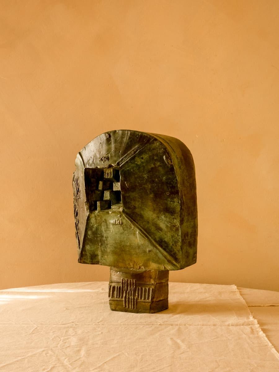 Sculpture en bronze en forme de tête à double face aux accents cubistes, œuvre anonyme. Les formes géométriques gravées en relief apportent de la profondeur à la sculpture. Associé à la combinaison de la patine de couleur verte sur les tons foncés,