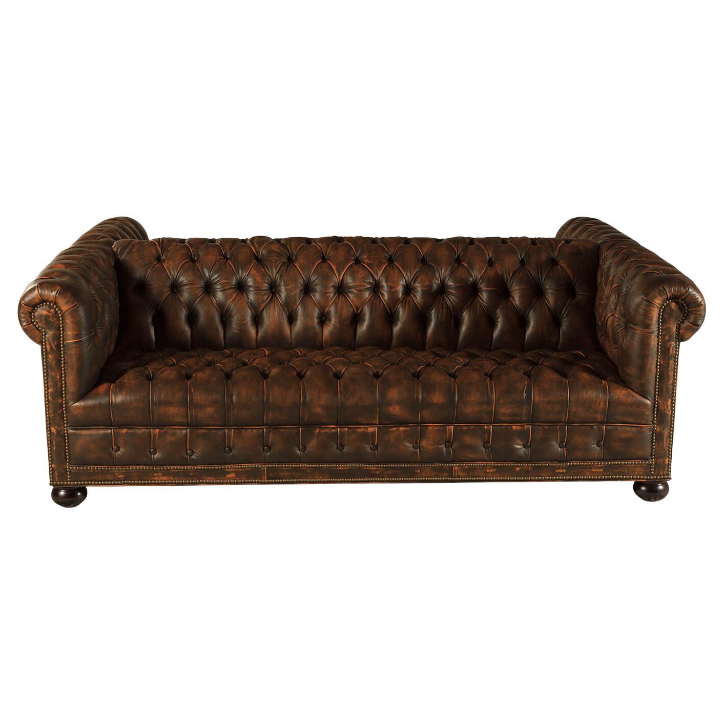 Ce canapé en cuir est revêtu de notre cuir Newport Toffee de haute qualité. Avec dossiers et coussins d'assise tuftés serrés en mousse haute densité, avec détails de têtes de clous en laiton finition naturelle, surélevés sur des pieds en forme de