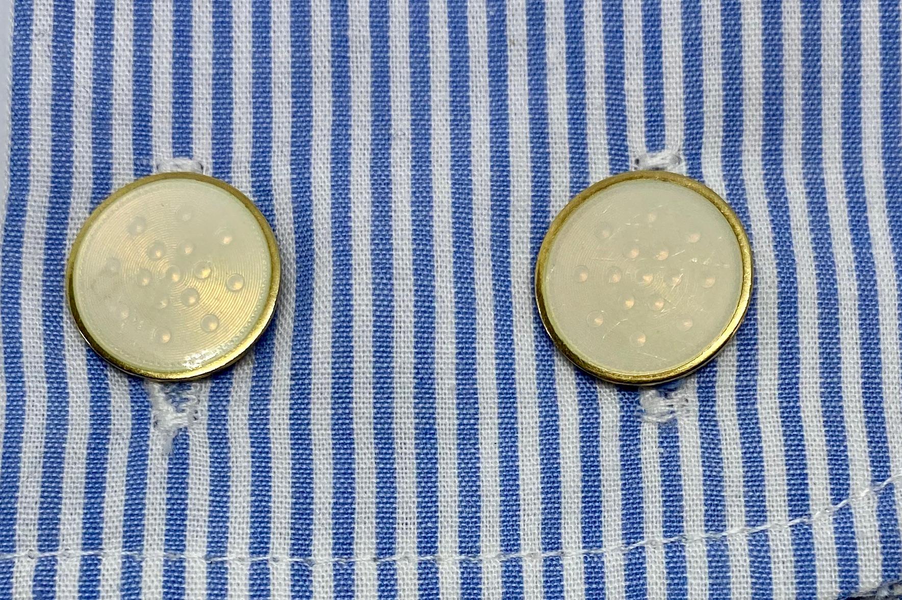 These double-sided cufflinks feature four round faces, each measuring 15.5 mm in diameter, and creme-colored enameling over engraved circles. They're set in yellow gold and joined by solid, high-quality links stamped 14K.

The creme enamel is
