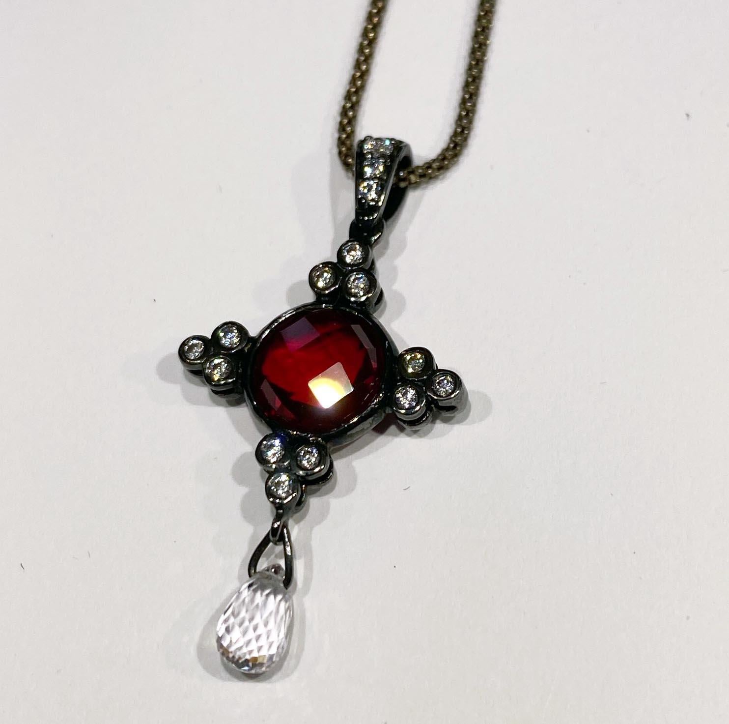 A Double Sided Cultured Sapphire & Ruby Pendant set in Blackened Silver
This Double Sided Cultured Sapphire & Ruby Pendant set in Blackened Silver Features a 3.04 Carat Round Checkerboard Cut Cultured Ruby accented by 27 Cultured White Round