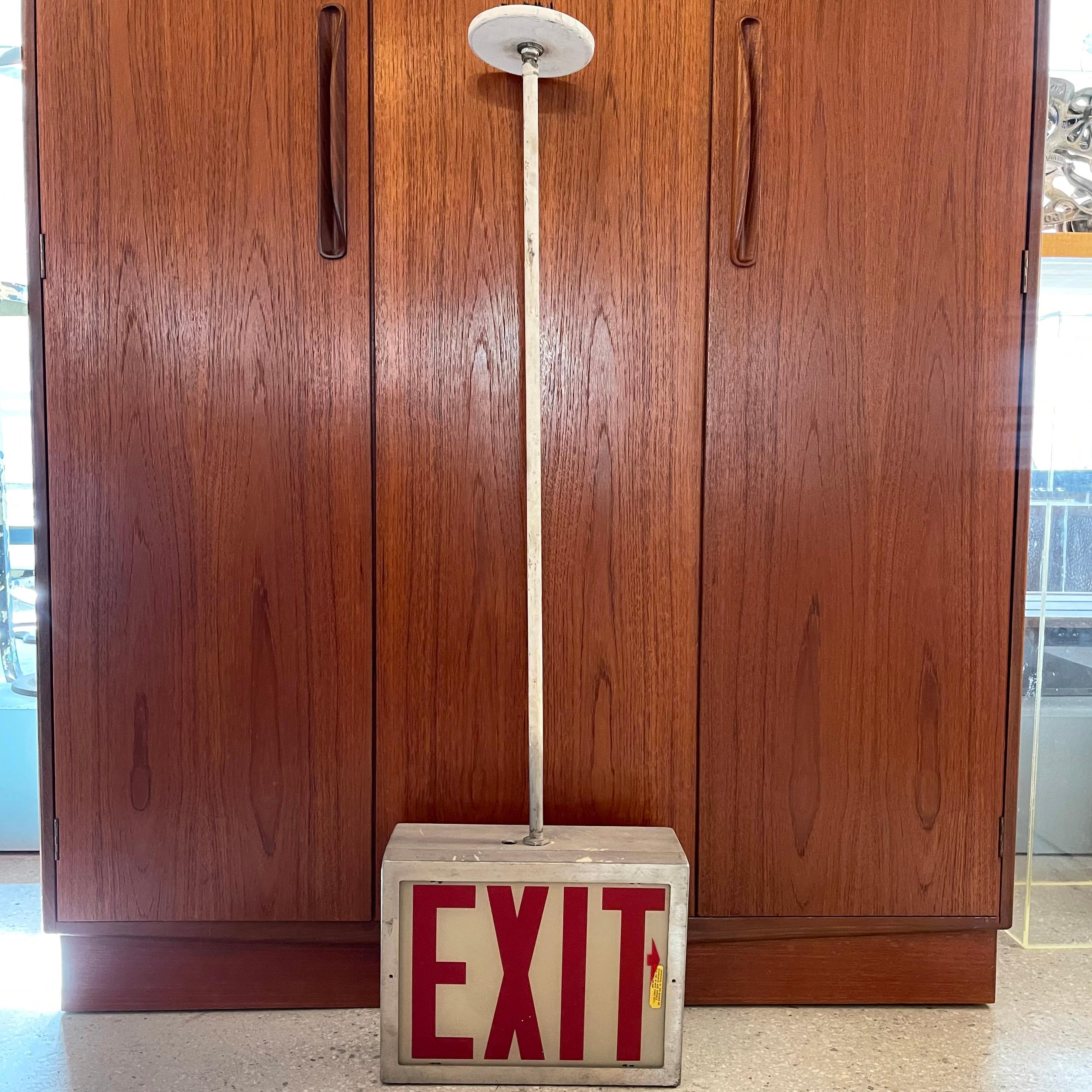 Midcentury, dobule-sided, flush-mount, exit sign light features a tapered aluminum, 10 inch height cube with glass EXIT shades on a painted steel pole with ceiling canopy.