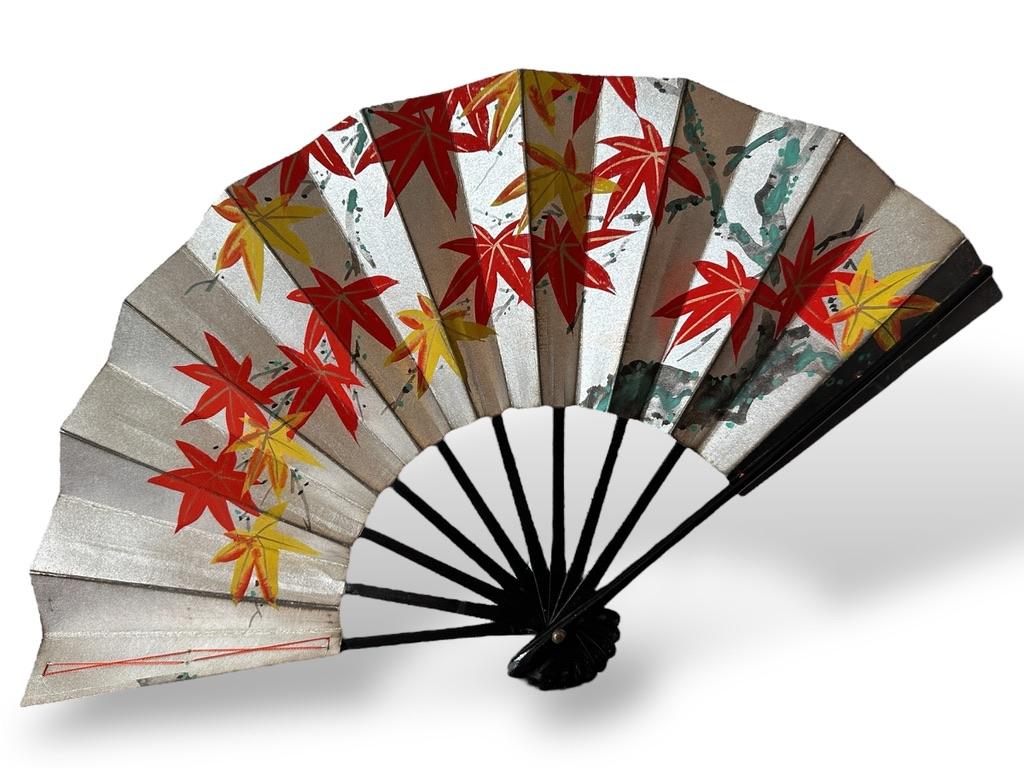 Japón, periodo Edo (1603-1868)
Tamaño: 49 × 30 cm

Magnífico abanico plegable japonés (ōgi) de dos caras, pintado a mano sobre papel ricamente decorado con pan de oro y plata. Una cara representa una dinámica escena samurai, mientras que el reverso