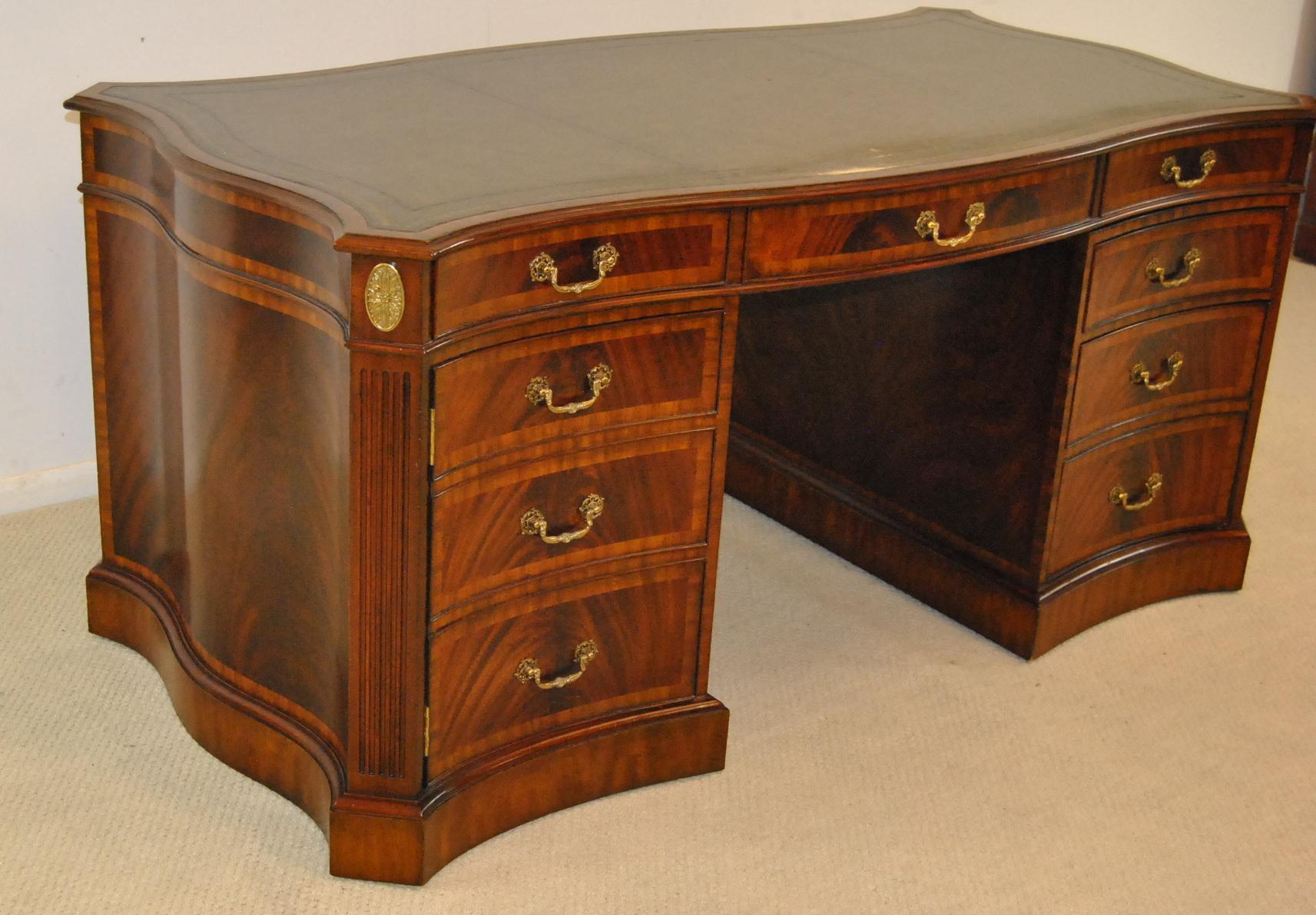 An impressive double sided partners desk by Maitland-Smith. This fantastic desk feature banded inlay drawers, serpentine sides and a leather top. There are two file drawers, two doors and six drawers. Both sides are matching. The dimensions are 64