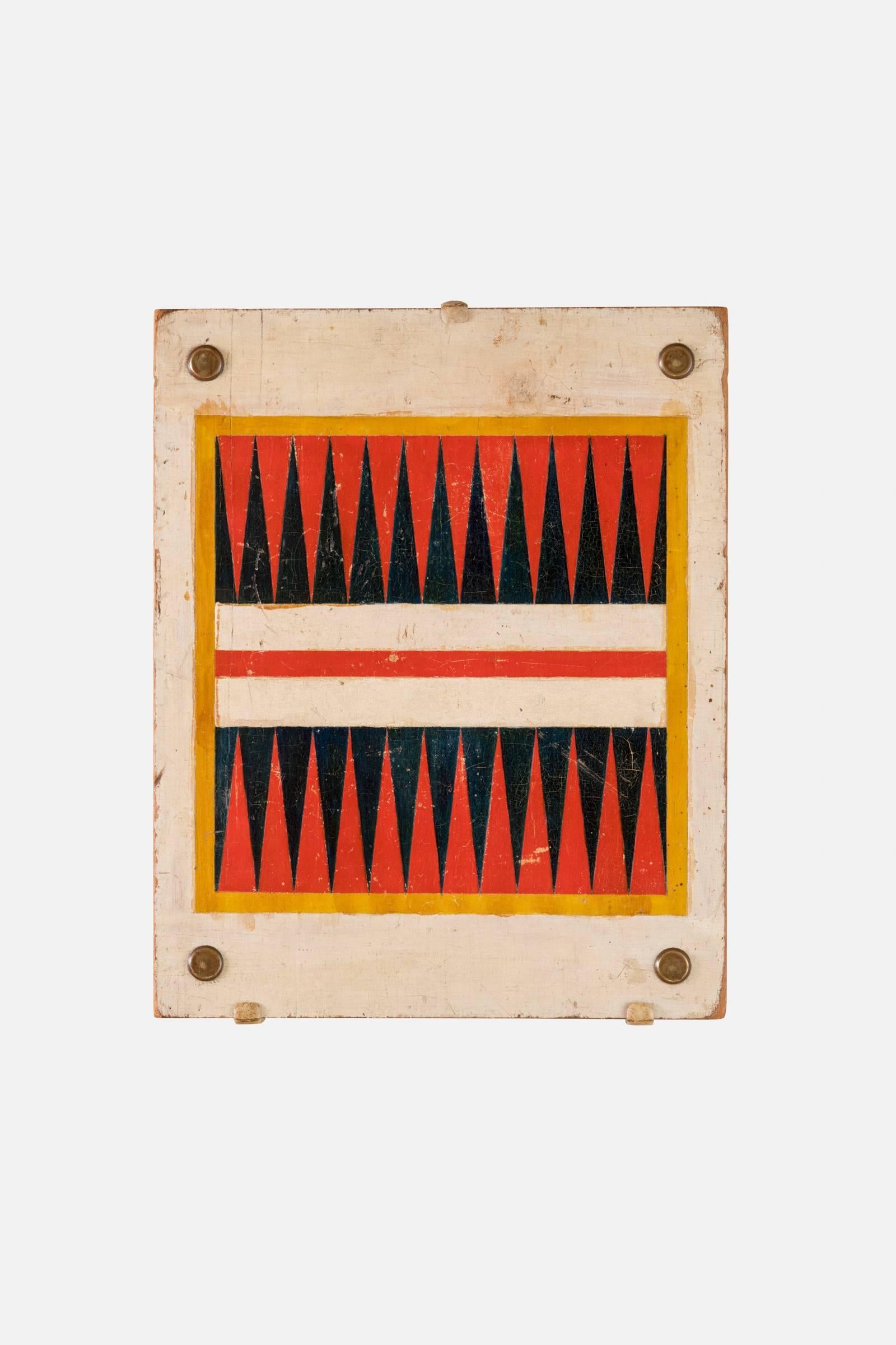 A double-sided gameboard painted for backgammon and checkers.
American, circa 1900
Pine with original incised and painted finish with brass caps

This piece can be mounted for display of either side.