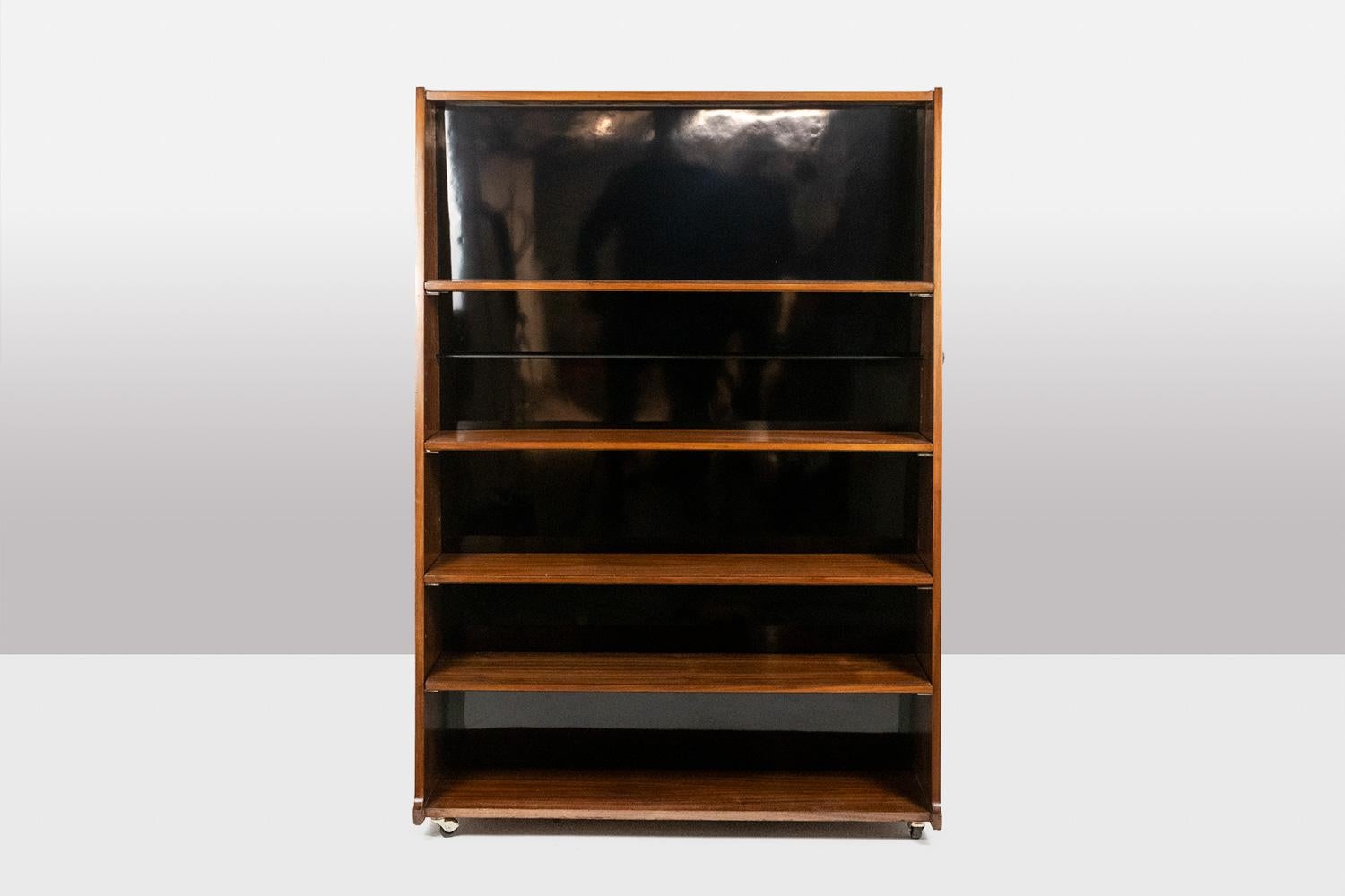 Mid-20th Century “Double-sided” rosewood bookcase on casters. Circa 1960. LS58761008H For Sale