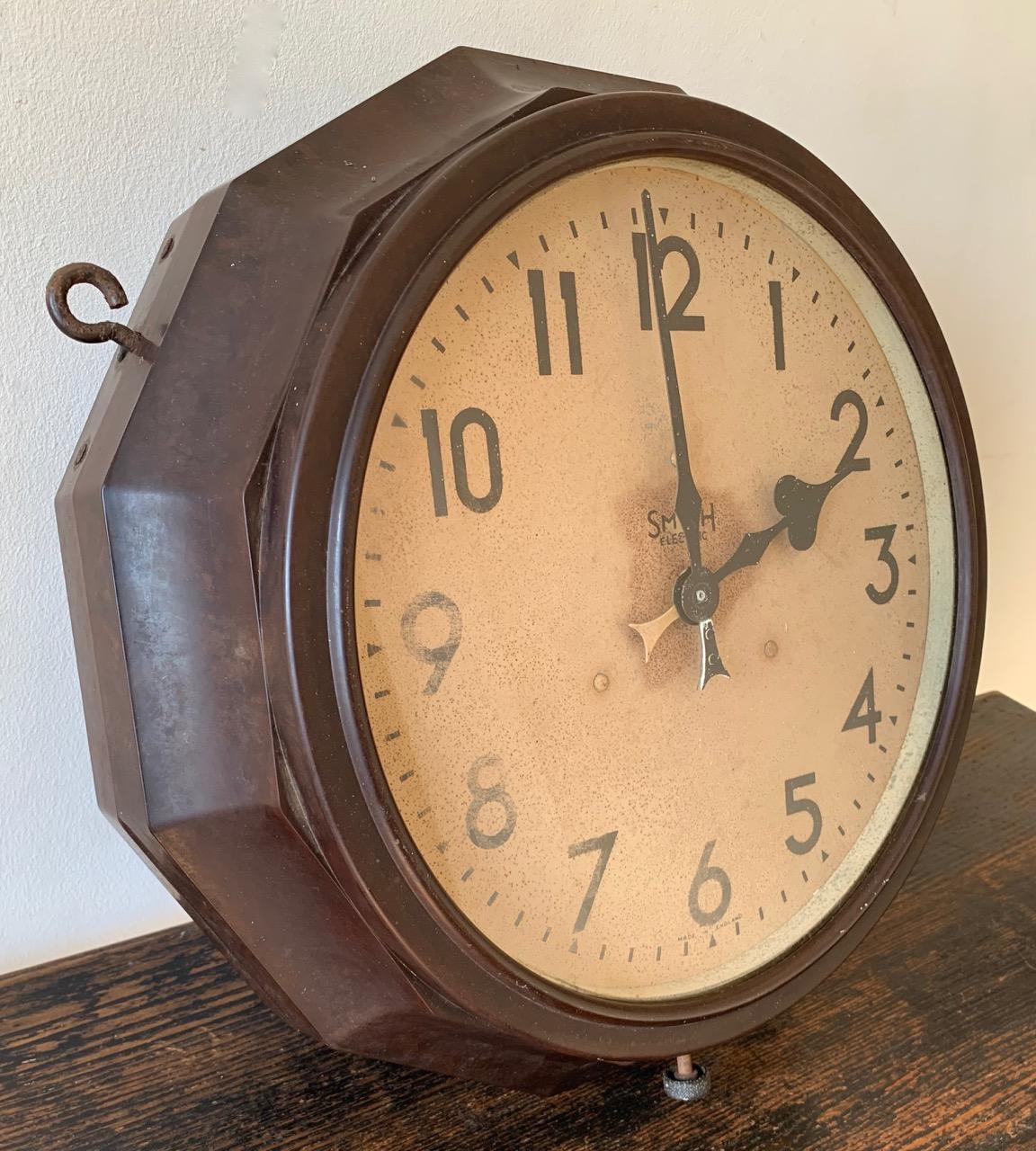 A rare double sided clock by Smith Electric. The case is Bakelite and the face is painted metal. The case is a rare 12 sided polygon shape with original hanging loops. The original electric movement didn't work so has now been fitted with a reliable
