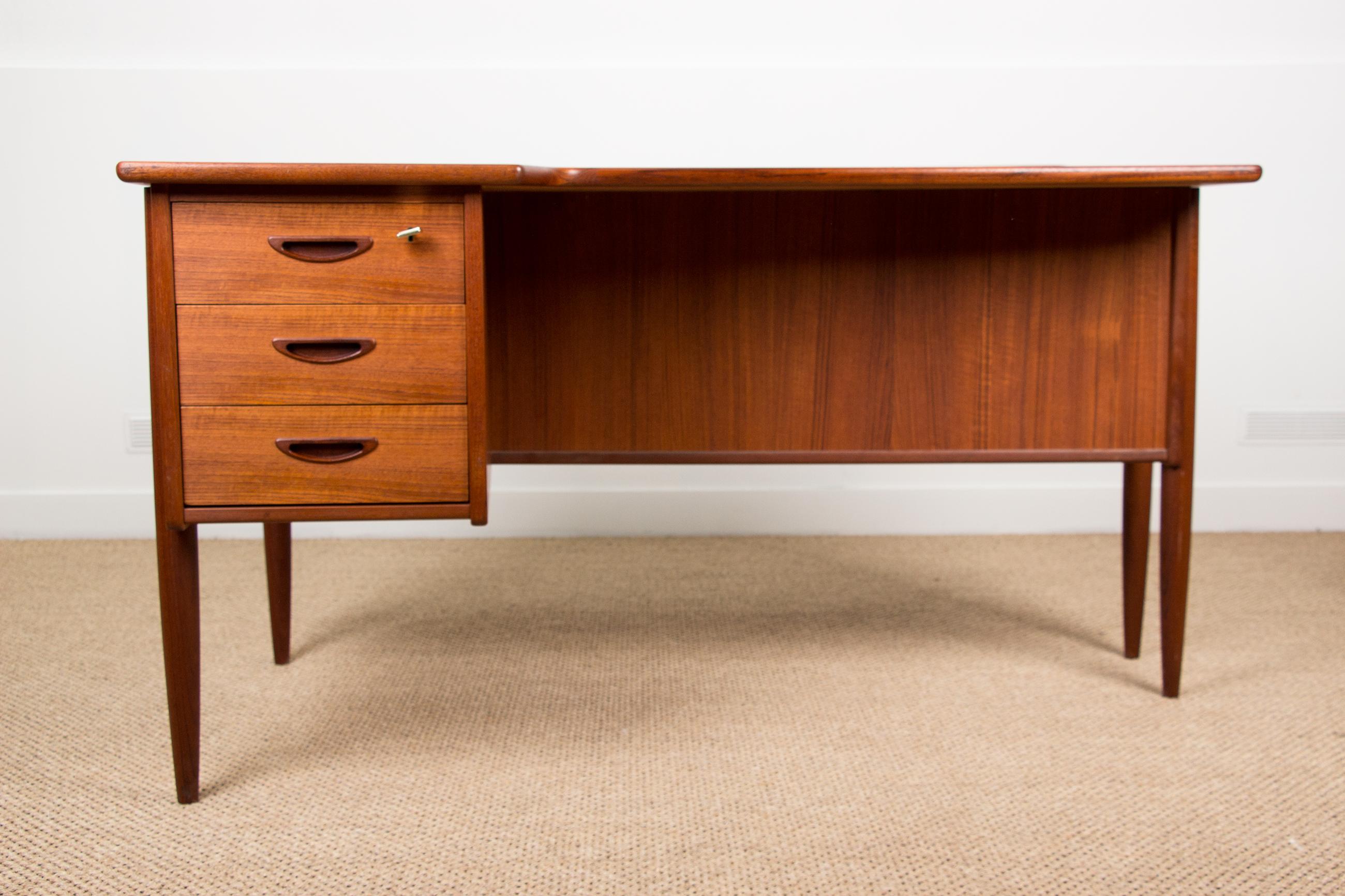 Superb Scandinavian desk in the shape of a boomerang, front side with 3 drawers, back side with a bar door and an interior shelf on the left and a storage niche on the left. Two keys provided.