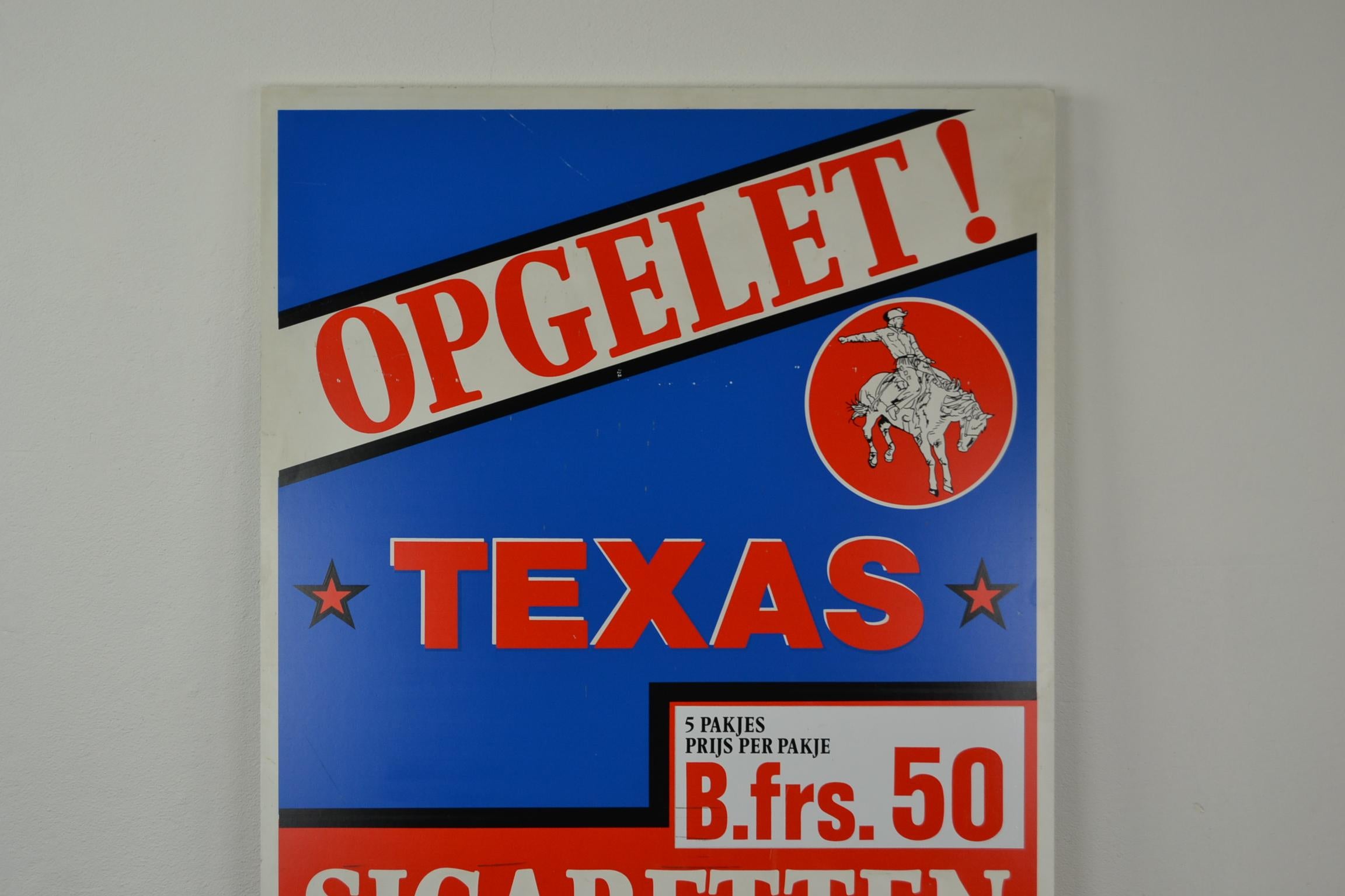 Colorful double sided sign for Texas cigarettes. 
A large red and blue advertising sign - billboard with a logo of a Texas cowboy on a horse. This publicity sign was probably used as a sidewalk sign. 

This vintage tobacco sign is decorative.