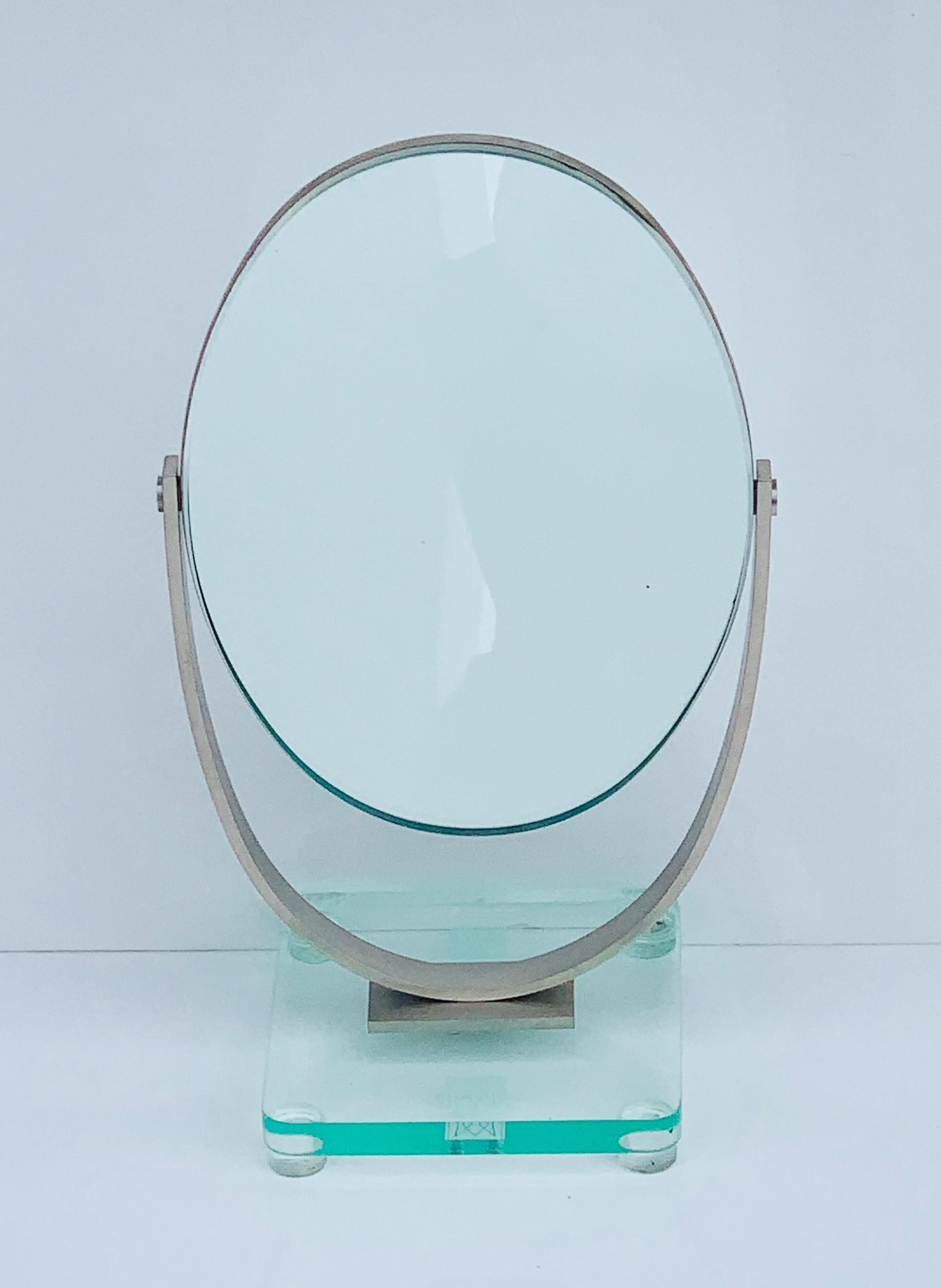 Voici le miroir de courtoisie double face de Charles Eleg Jones, États-Unis, années 1970 - une pièce intemporelle qui allie harmonieusement fonctionnalité et élégance. Ce miroir exquis est le complément idéal d'un meuble de toilette ou d'une