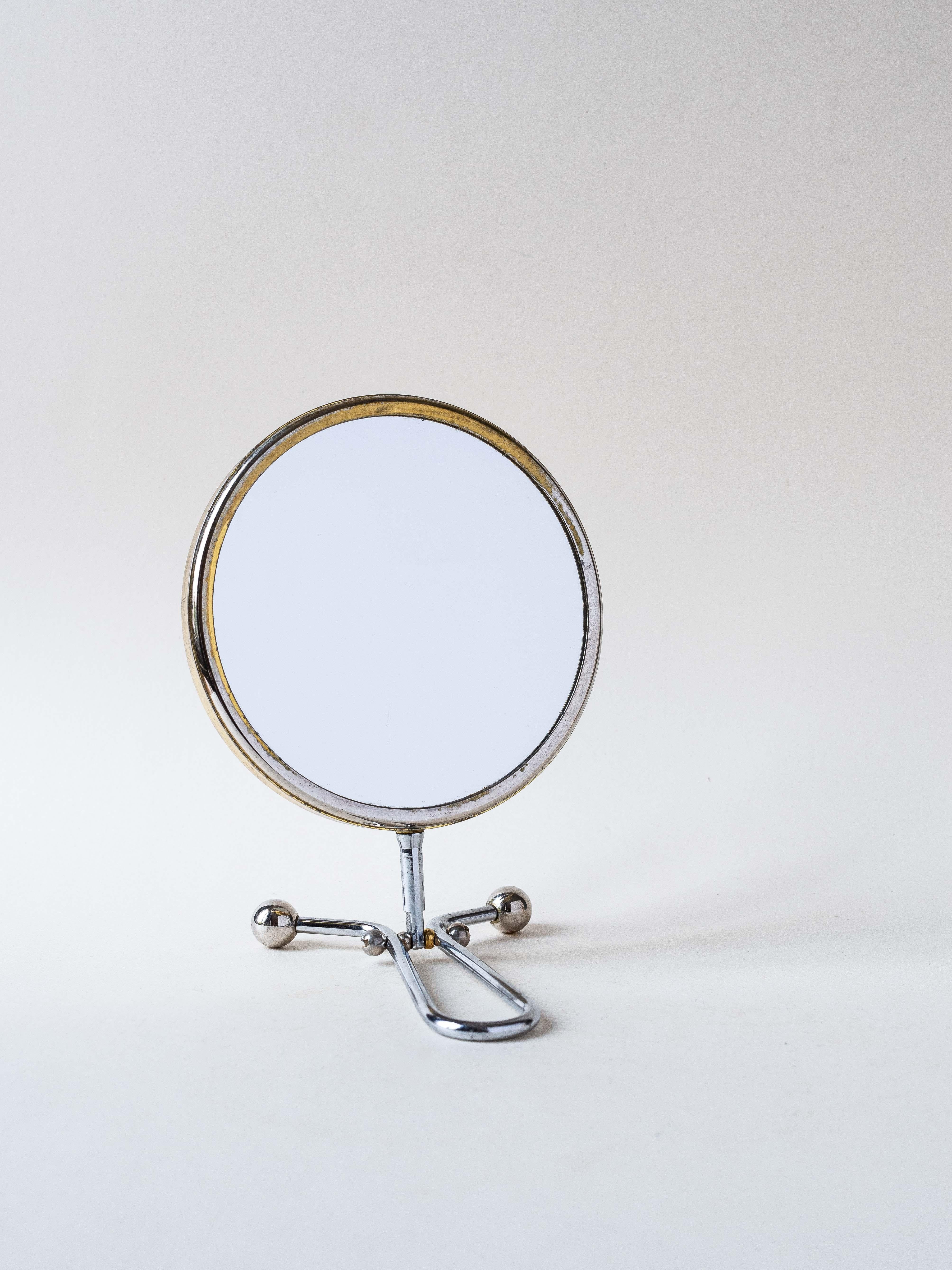 Very elegant small double-sided vanity mirror, made of silver and gold metal, from the 1950s. 

The mirror can be flipped to be used on either side. the mirror is double sided and flips from regular to Magnification

One side is a classic mirror,