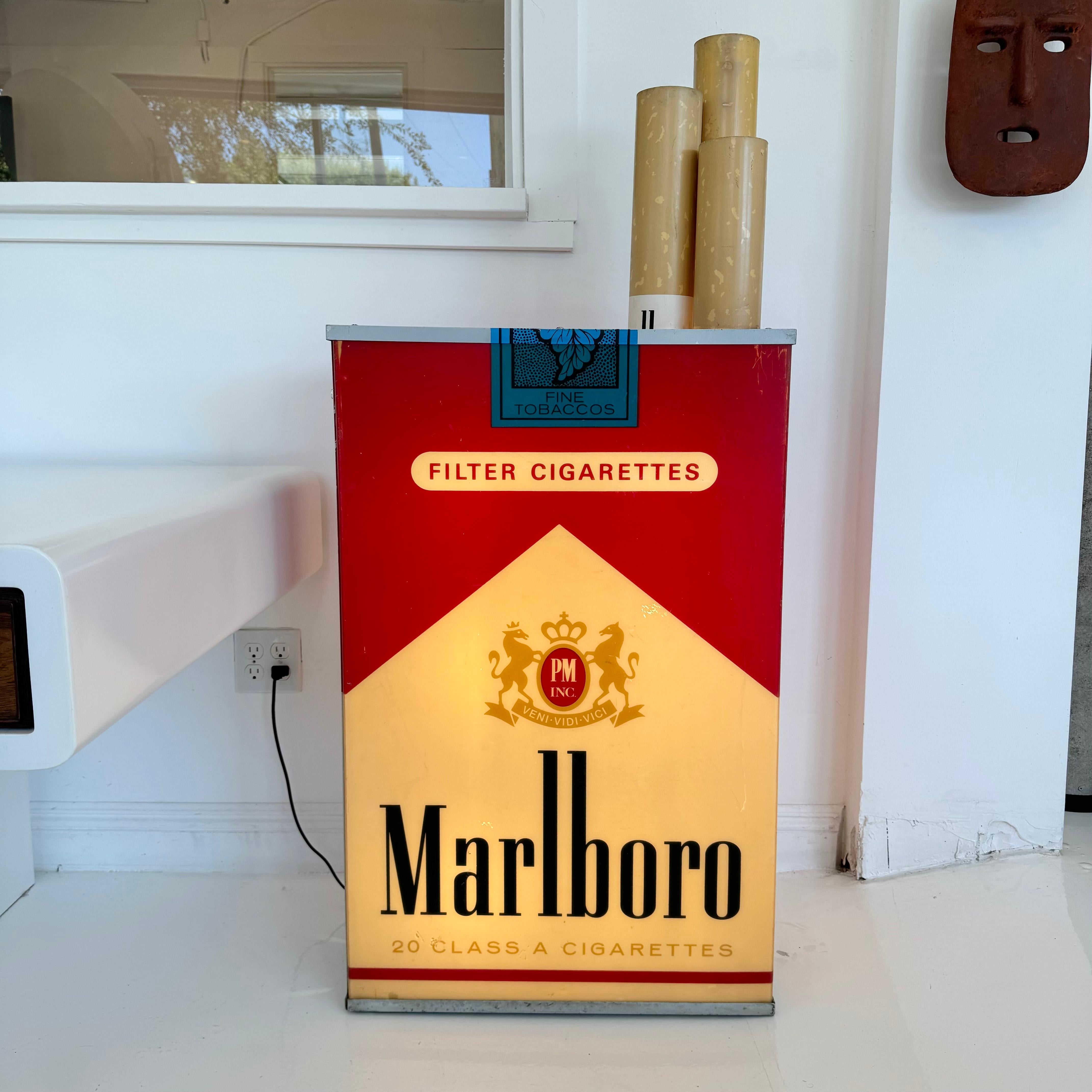 Incredible vintage advertising light up box by Marlboro. Massive scale. Looks great hanging on the wall or on the ground. Sun fading gives this piece a beautiful yellowish hue and patina. Acrylic sides and cigarettes with metal frame. One of the