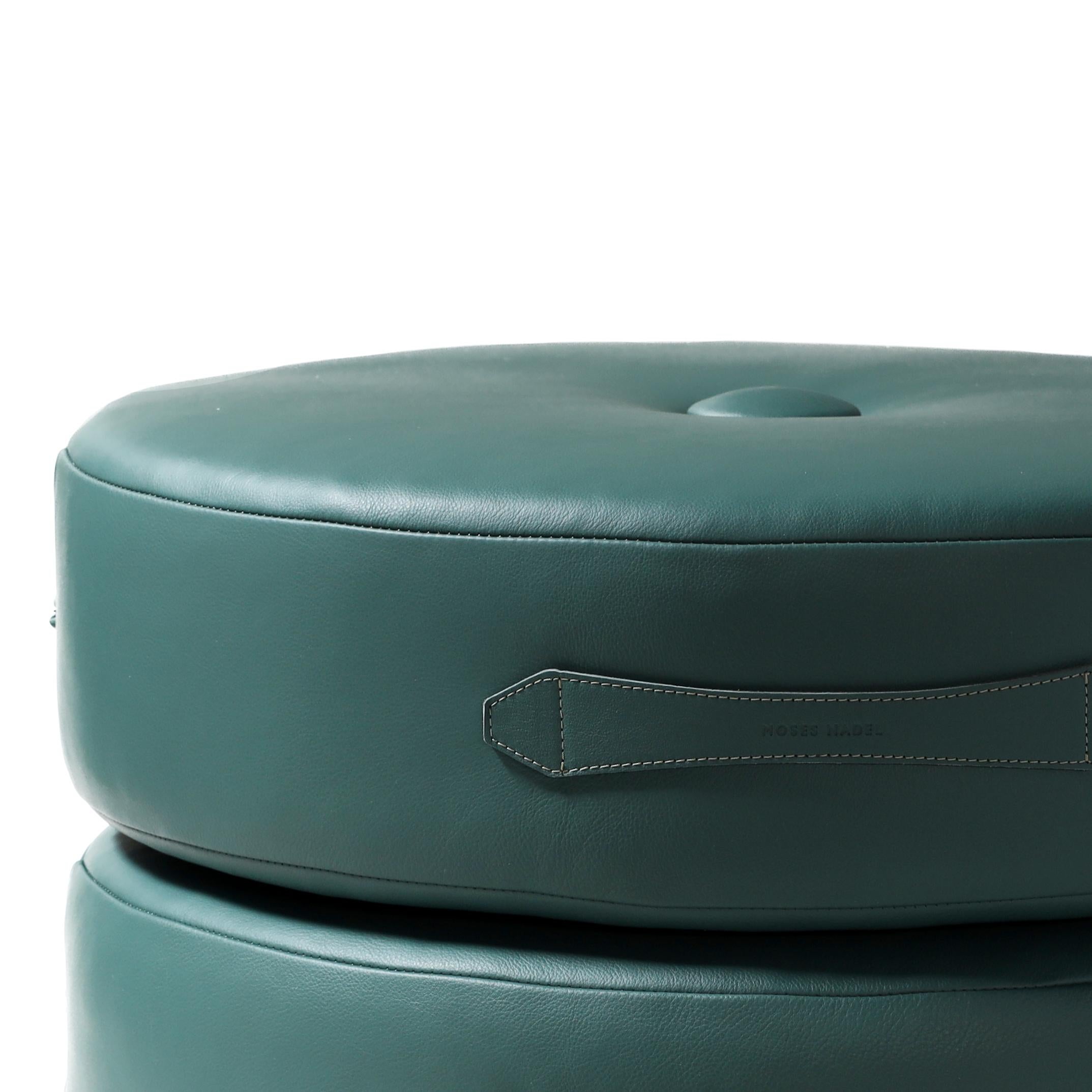 Dieses Set aus zwei runden Lederkissen kann gestapelt werden, um es aufzubewahren oder als Sitzgelegenheit für niedrige Sitzplätze zu verwenden. Farbpalette von oben nach unten: Seaweed Green Leder (auch in Light Cocoa Leder und weiteren Farben auf
