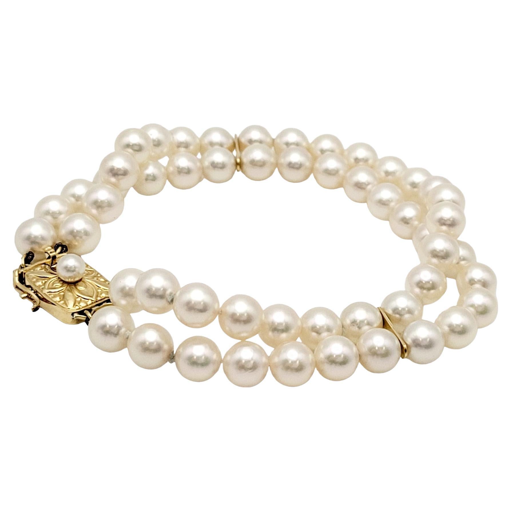 Dieses zeitlose Armband zeigt eine harmonische Verschmelzung von klassischen Perlen und opulentem 18-karätigem Gelbgold. Das Armband besteht aus einem doppelten Strang glänzender Perlen, von denen jede einzelne sorgfältig wegen ihres strahlenden