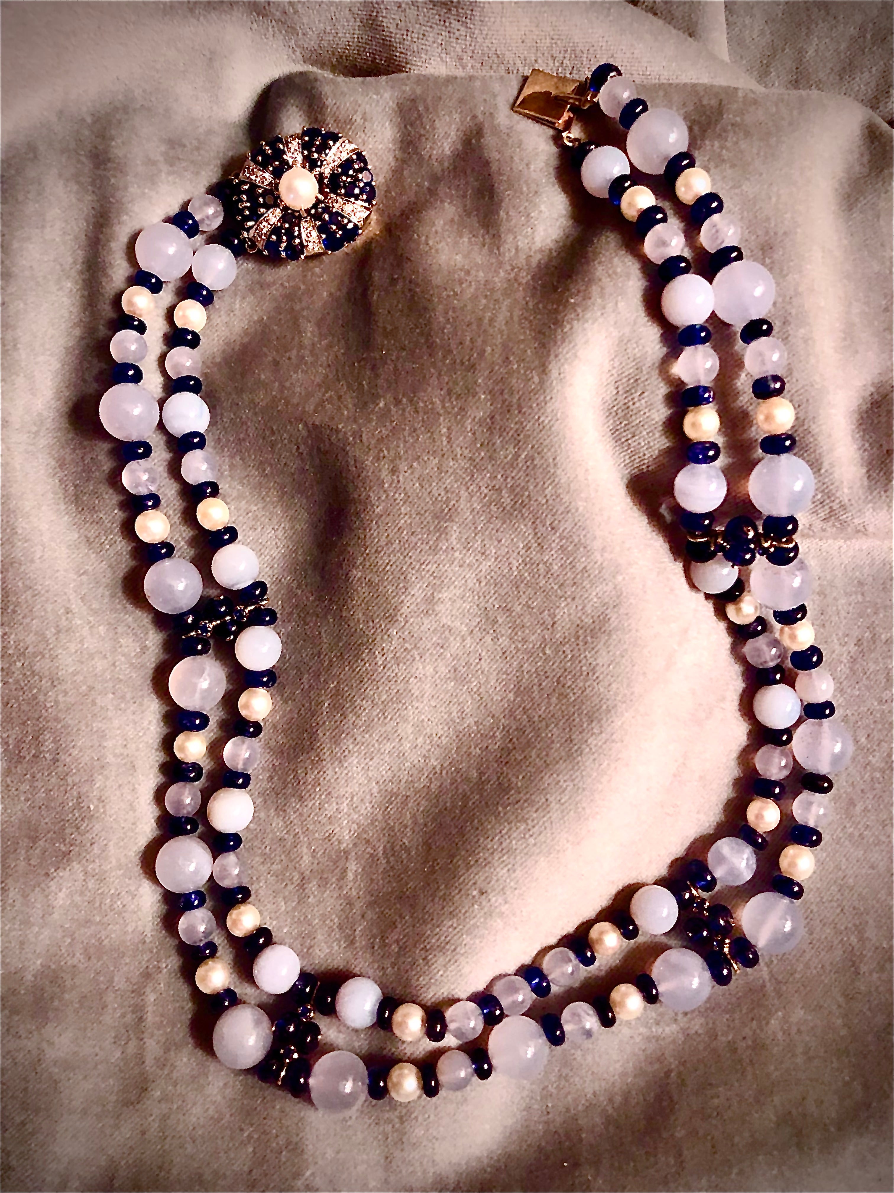 Les perles de calcédoine bleue translucide sont flanquées de saphirs bleus ronds et lisses qui sont ensuite centrés sur des perles de culture rondes d'un blanc crémeux. Les deux rangs de perles somptueuses sont séparés par des séparateurs en or