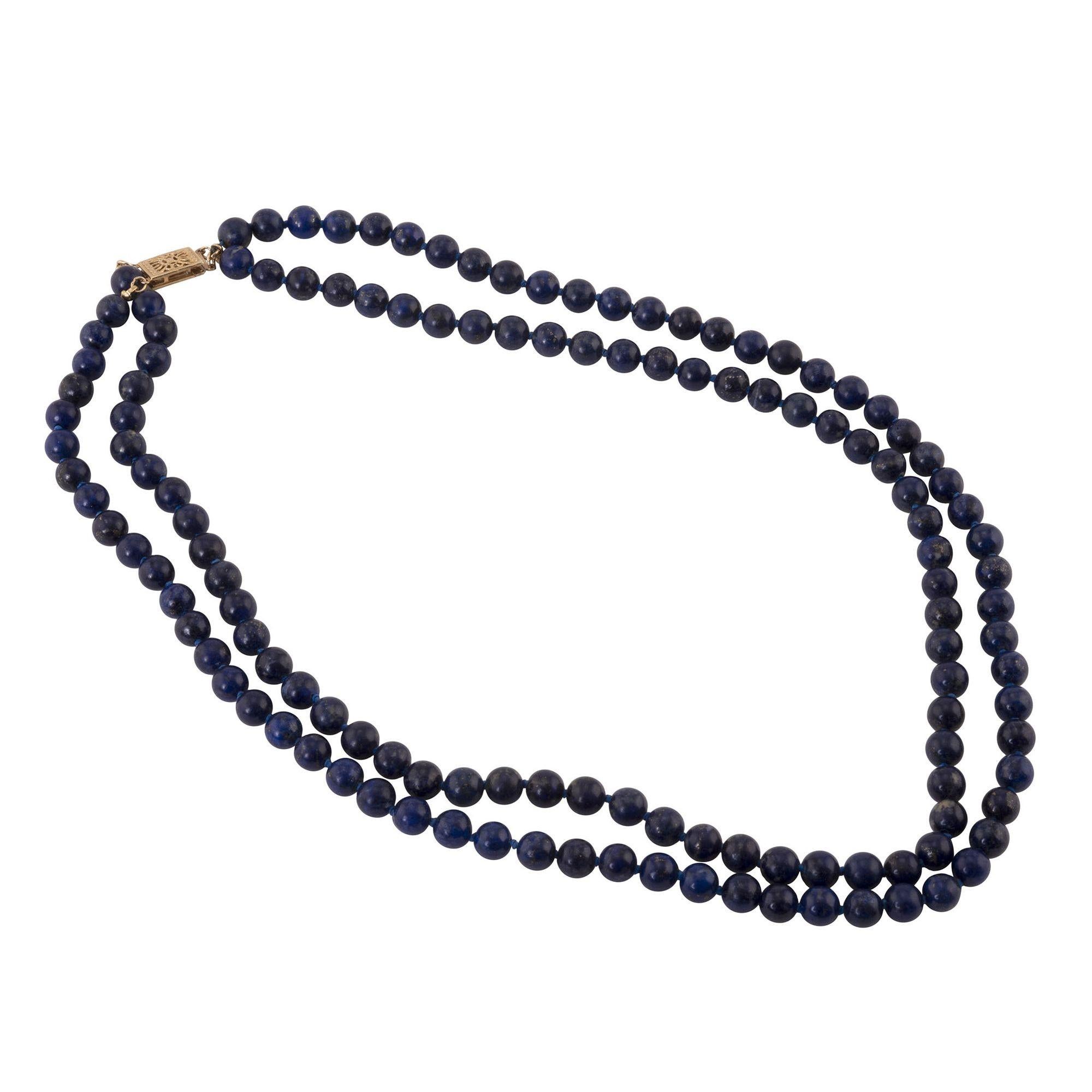 Estate double strand lapis bead necklace. This necklace features two strands of knotted lapis beads with a 14 karat yellow gold clasp. [RHAW 59]

Dimensions
18″L; 6.3mm beads