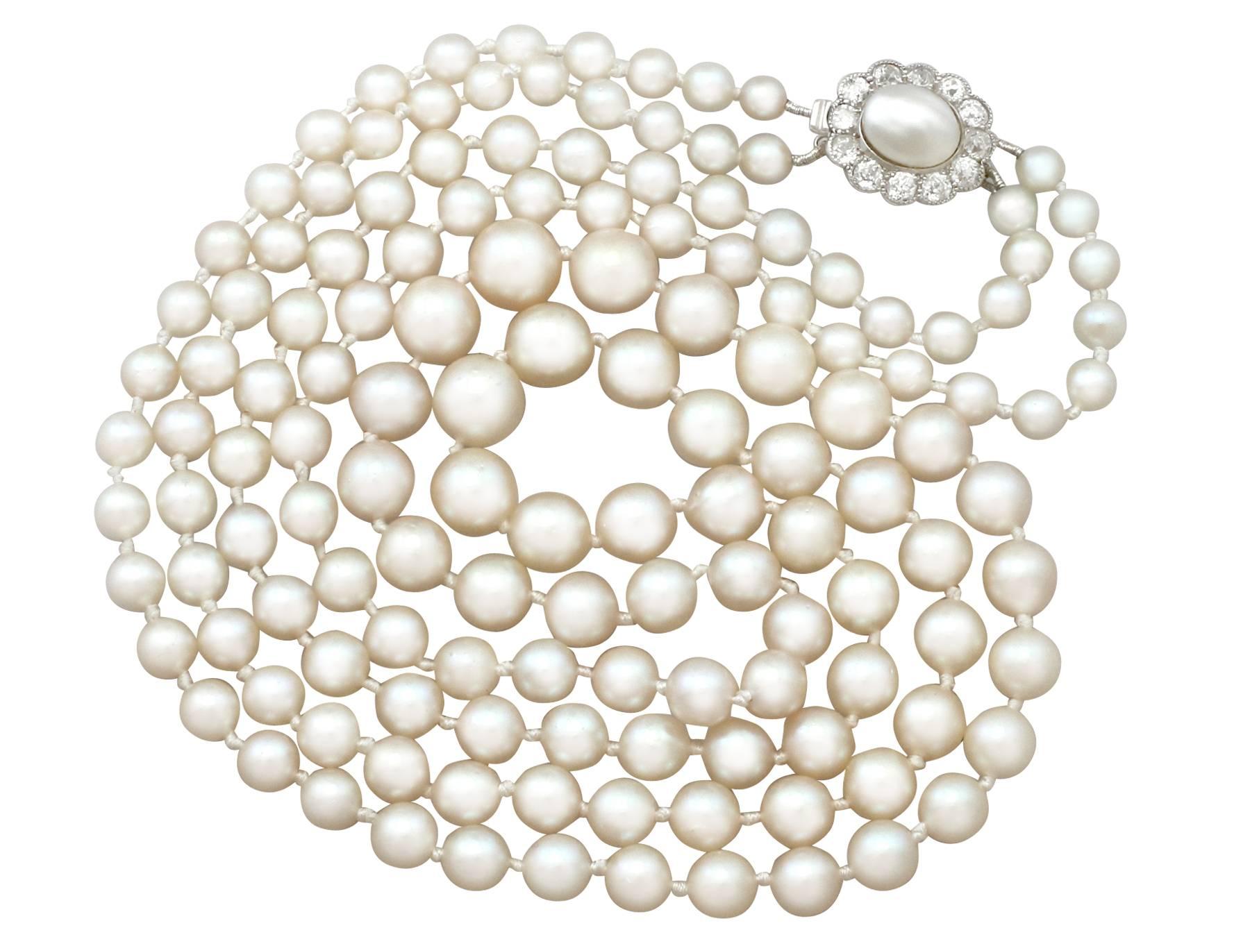 A fine and impressive vintage double strand cultured pearl necklace with an antique 0.84 carat diamond and natural pearl, 14 karat yellow gold, platinum set clasp; part of our diverse pearl jewelry collection.

This impressive vintage double strand