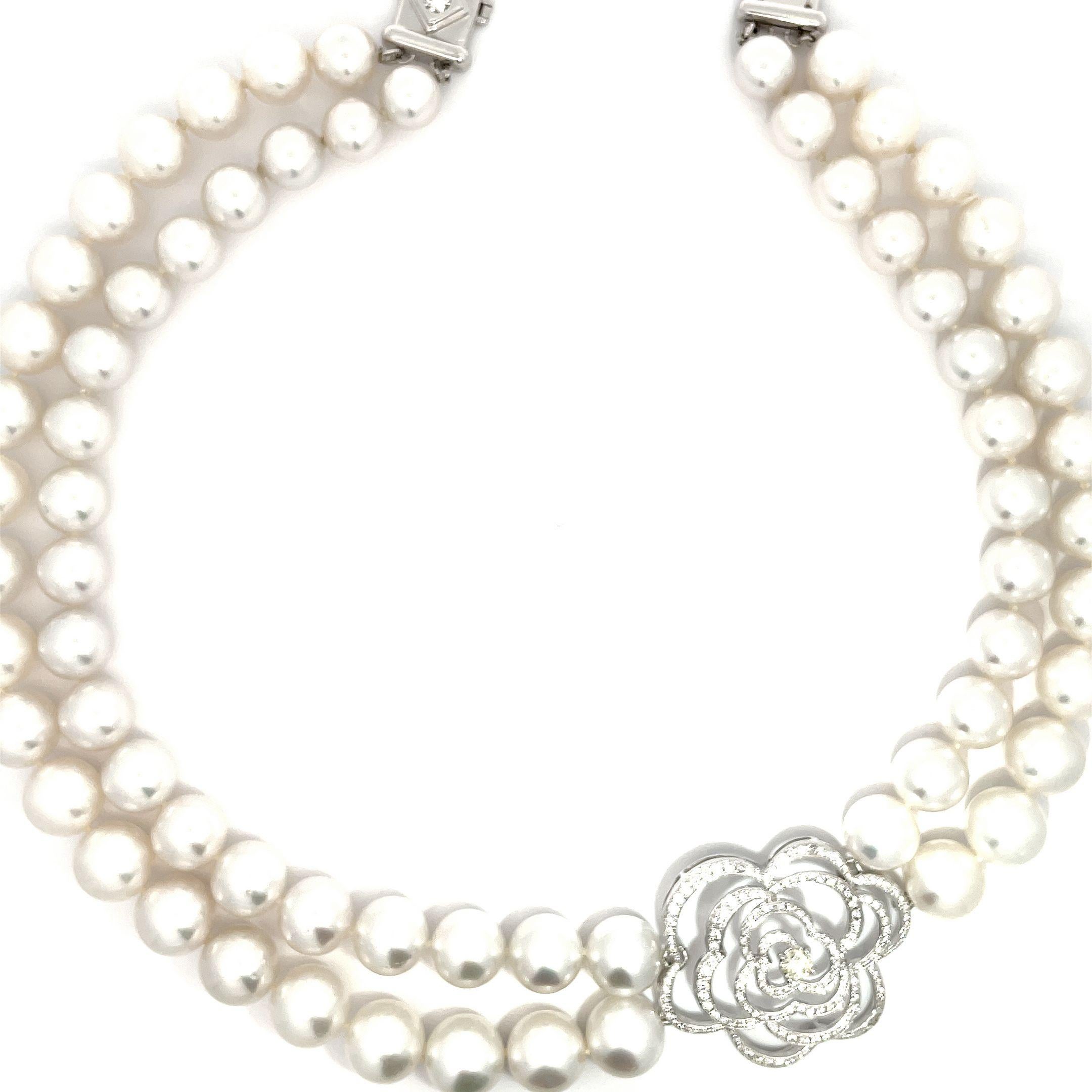 Cet élégant collier incarne le luxe et la finesse. Whiting en or blanc 18 carats, il présente un double rang de perles des mers du Sud d'une beauté naturelle allant de 9,2 à 11,8 mm. Un pendentif à motif de camélia en diamant de 2,35 carats placé au