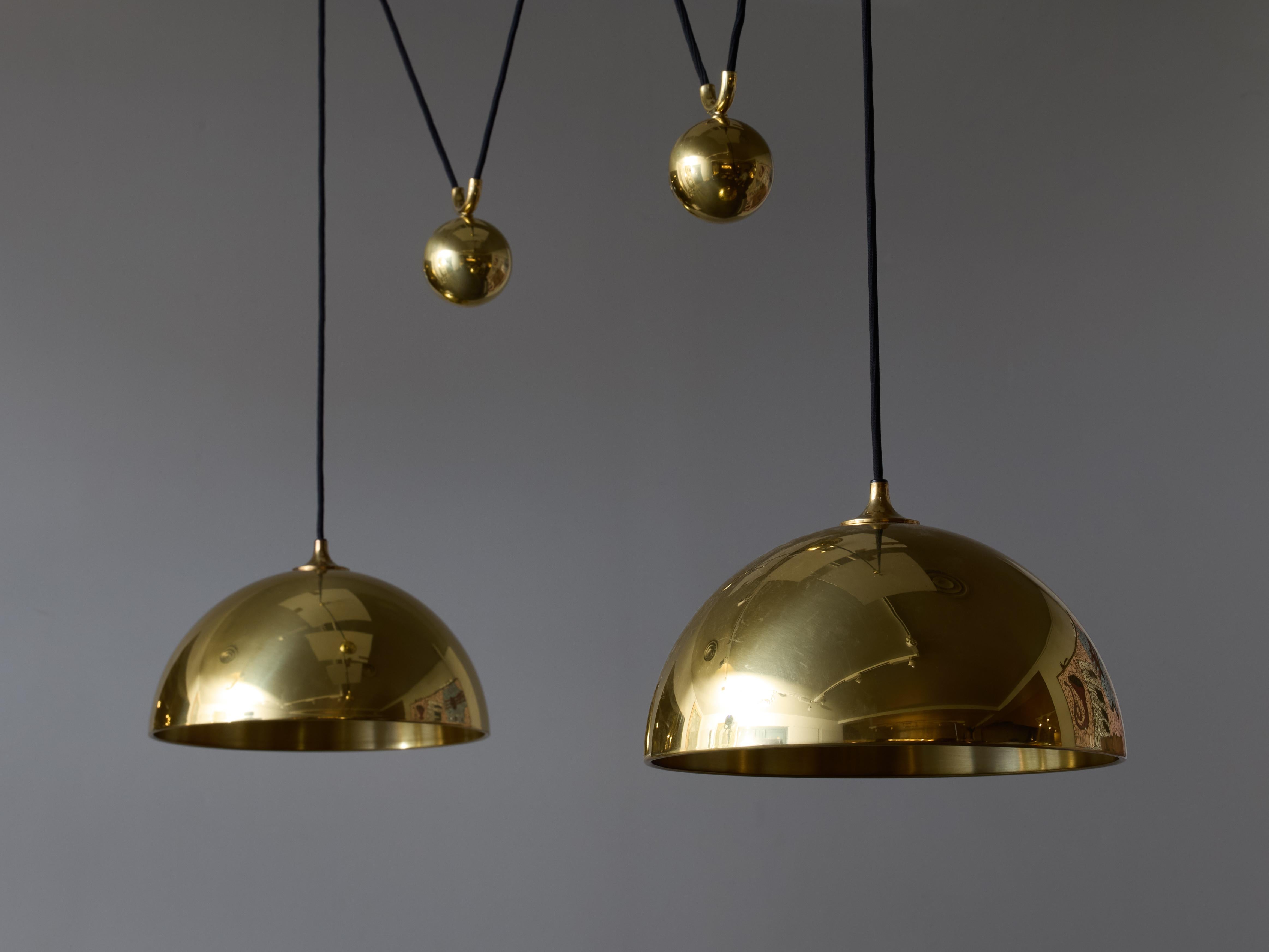 Suspension à double pendule du designer allemand Florian Schultz, cette pièce est composée de deux dômes reliés à deux fixations au plafond, sur les fils se trouvent également des contrepoids en laiton, l'ensemble se rassemblant dans un baldaquin
