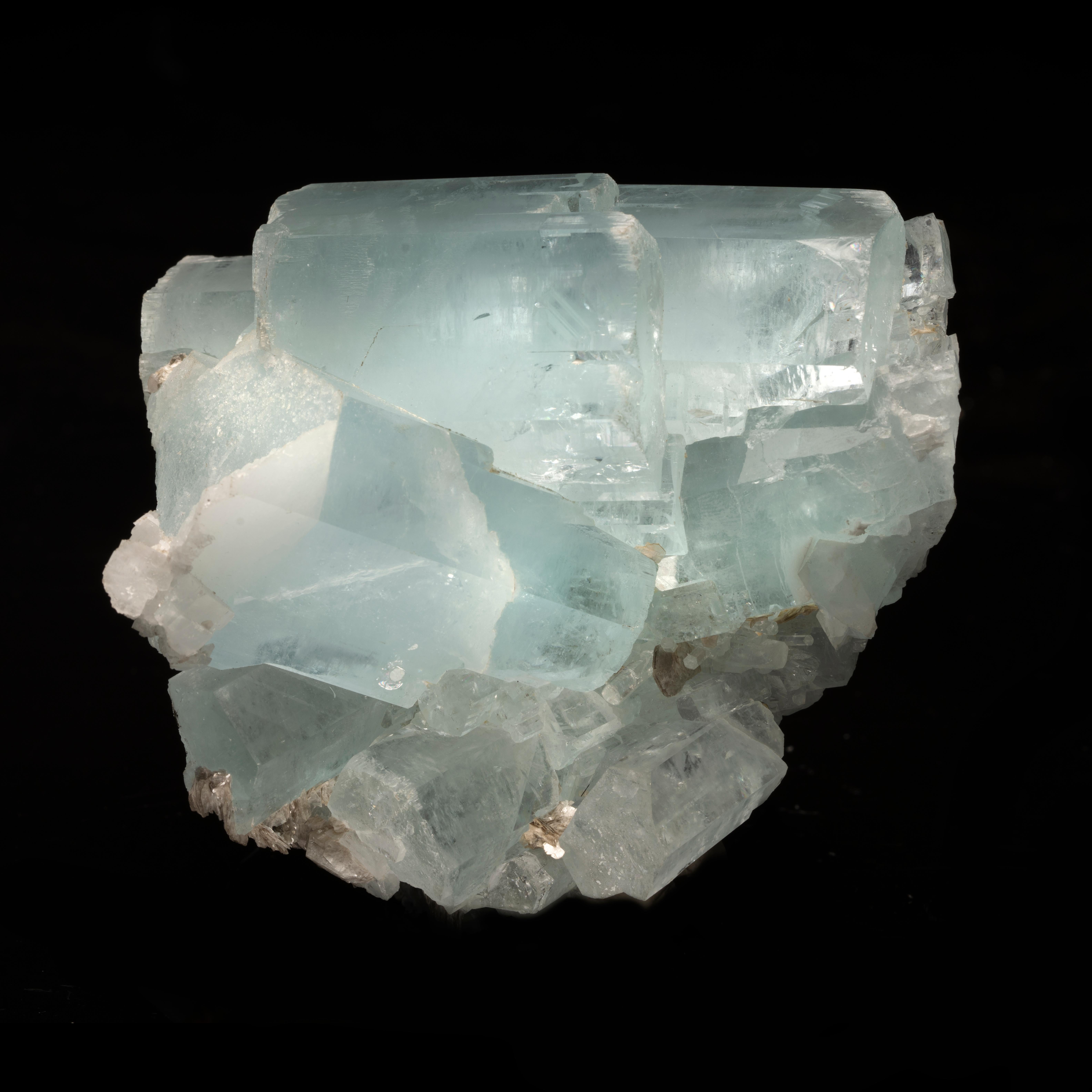 This unique, well pigmented sky blue aquamarine specimen features a cluster of translucent to shockingly clear double terminated crystals accented by lustrous flakes of muscovite. This piece comes out of Nagar in Gilgit-Baltistan, Pakistan. A