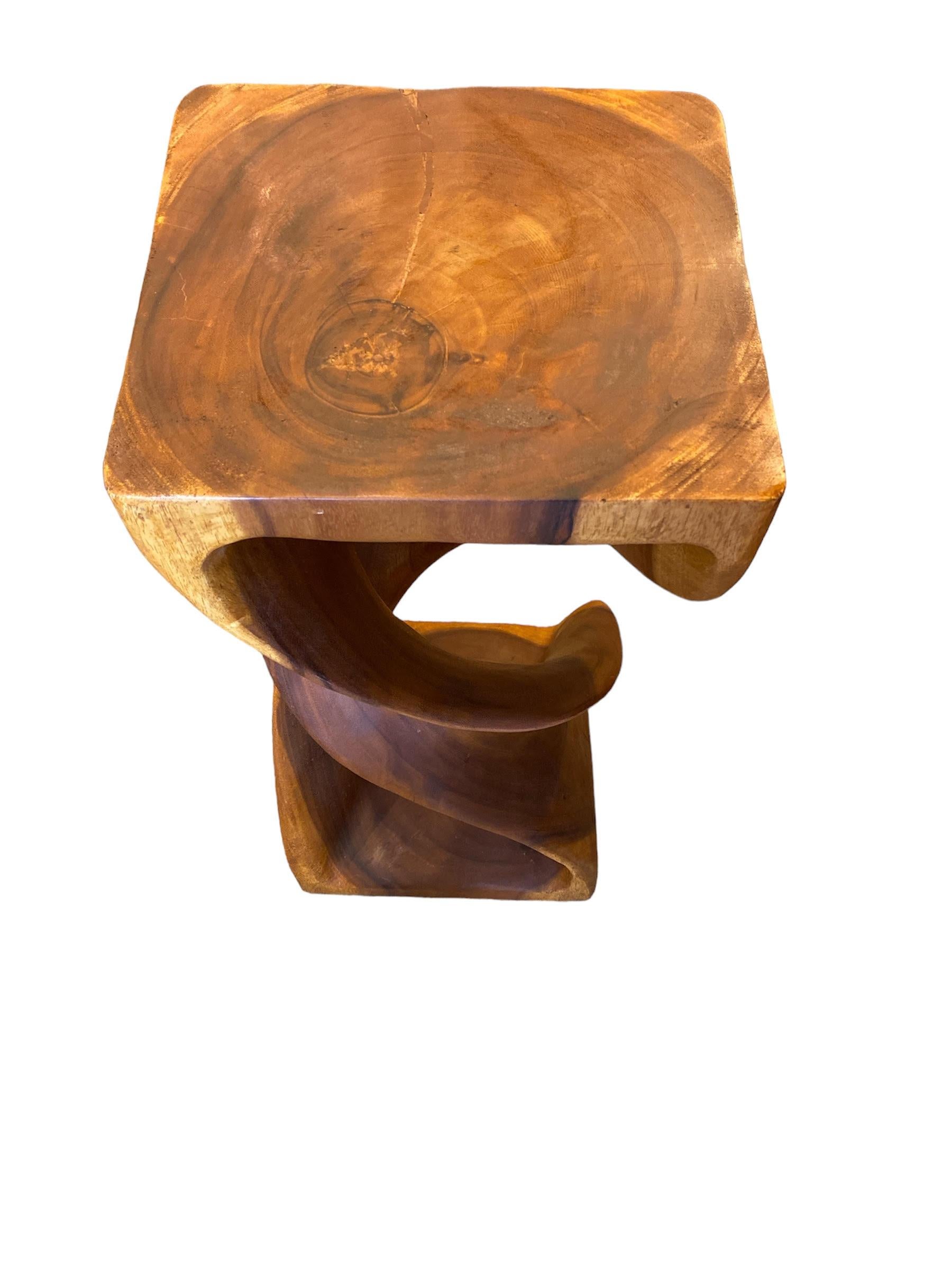 Smooth, uninterrupted lines are gracefully contrasted by rich, organic wood grain. This pedestal is a beautiful piece of natural chamcha wood that has been delicately carved into a spiral shape, resulting in a piece with a strong sense of motion