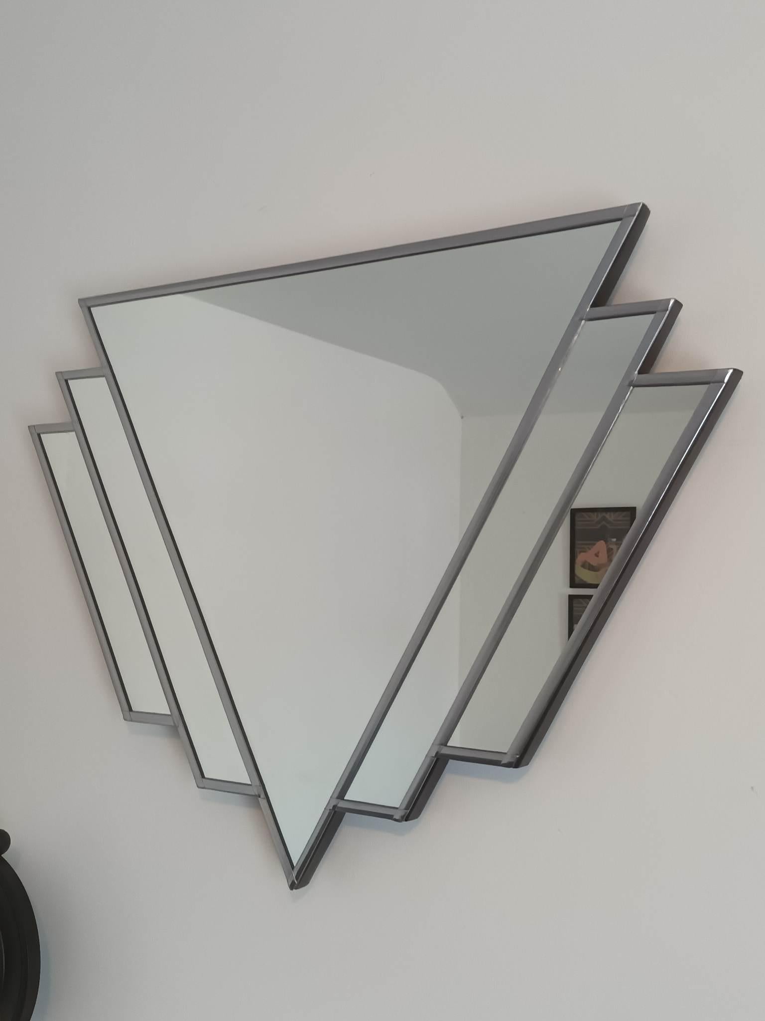 Notre Double W original est un miroir Art déco. En utilisant un centre de forme triangulaire comme point de départ, nous avons créé deux pièces de verre en forme d'éventail, toutes deux de longueurs différentes, pour créer l'un de nos designs les