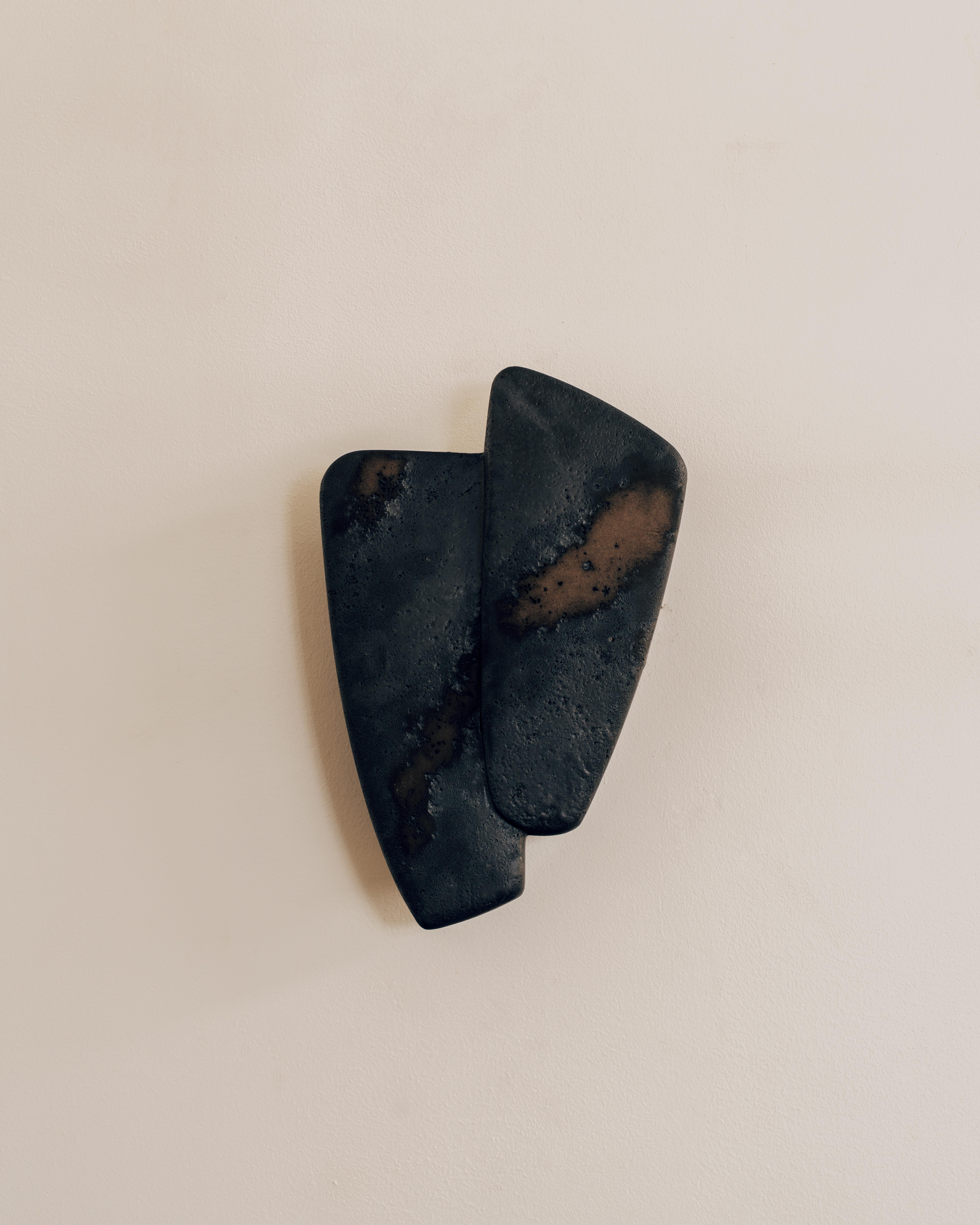 In 2024, Charlotte Besson-Oberlin, a master in the art of playing with volumes, created the Applique Double, a raw, refined lighting design in lava stone. Composed of two interlocking, overlapping shapes,
like leaves or a pair of wings, this wall