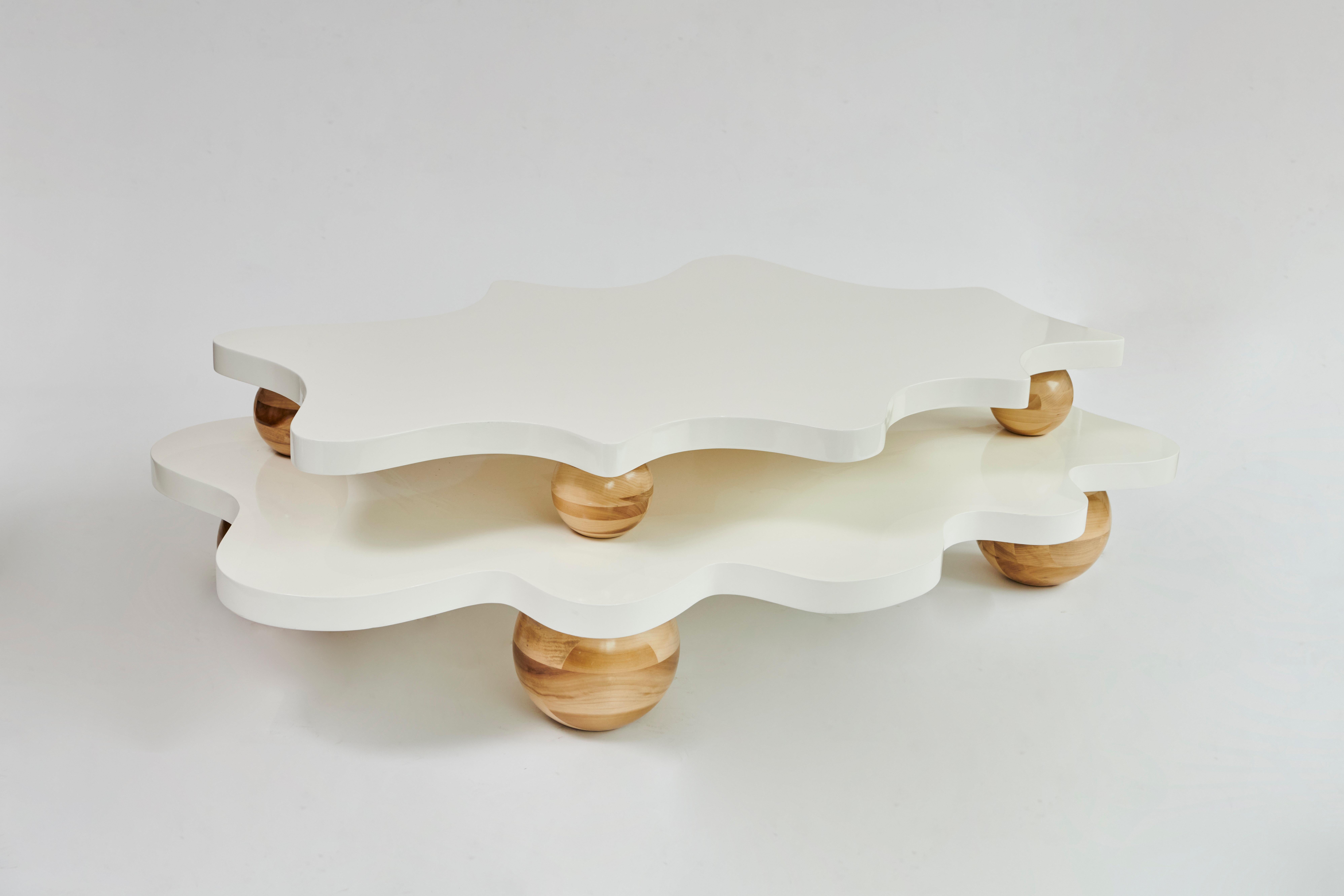 Made to order two-layer coffee table designed by Christian Siriano.

Material: White lacquer top with natural maple legs  (available in custom finish)

Dimensions

Bottom Layer:
Overall Width: 69”
Overall Depth: 51” 

Top Layer:
Overall Width: