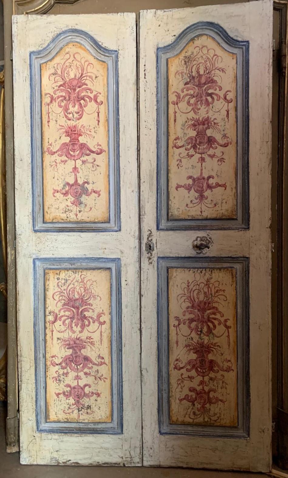 Antigua puerta de interior de doble hoja, de madera maciza, con paneles esculpidos y ricamente pintados con un diseño original de la época, que mantiene preciosos los hierros murales y las manillas originales de mariposa.
Dos puertas con paneles