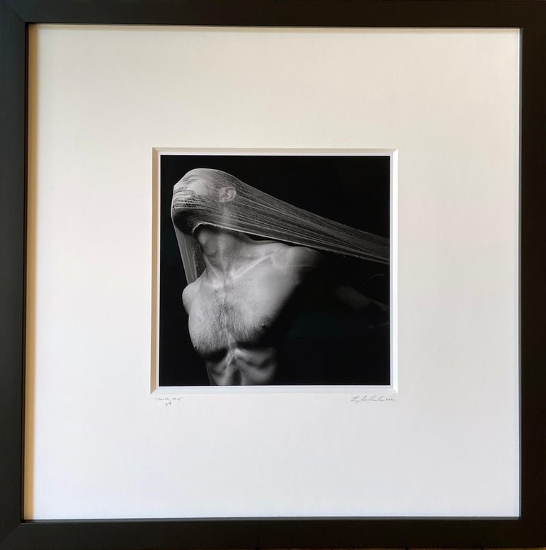 This male nude shrouded with a veil over his face captures the human form in an exquisite expression of emotion and movement.  The photo is double matted in a creamy white mat and framed in a simple wooden frame measuring 16.5 x 16.5 inches.

Doug