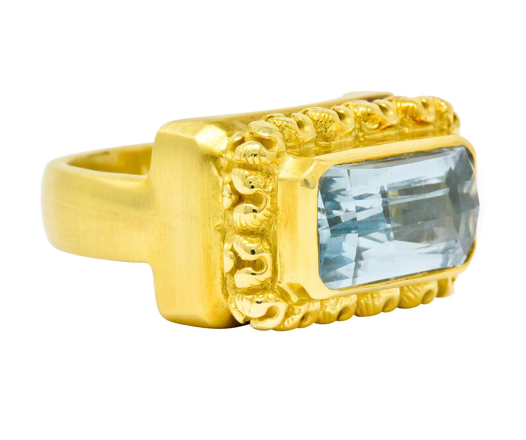 Centering a bezel set rectangular checkerboard cut aquamarine measuring approximately 14.0 x 7.0 mm; transparent and light blue in color

With a highly rendered blossom surround and pierced undercarriage details

Completed by a strong satin