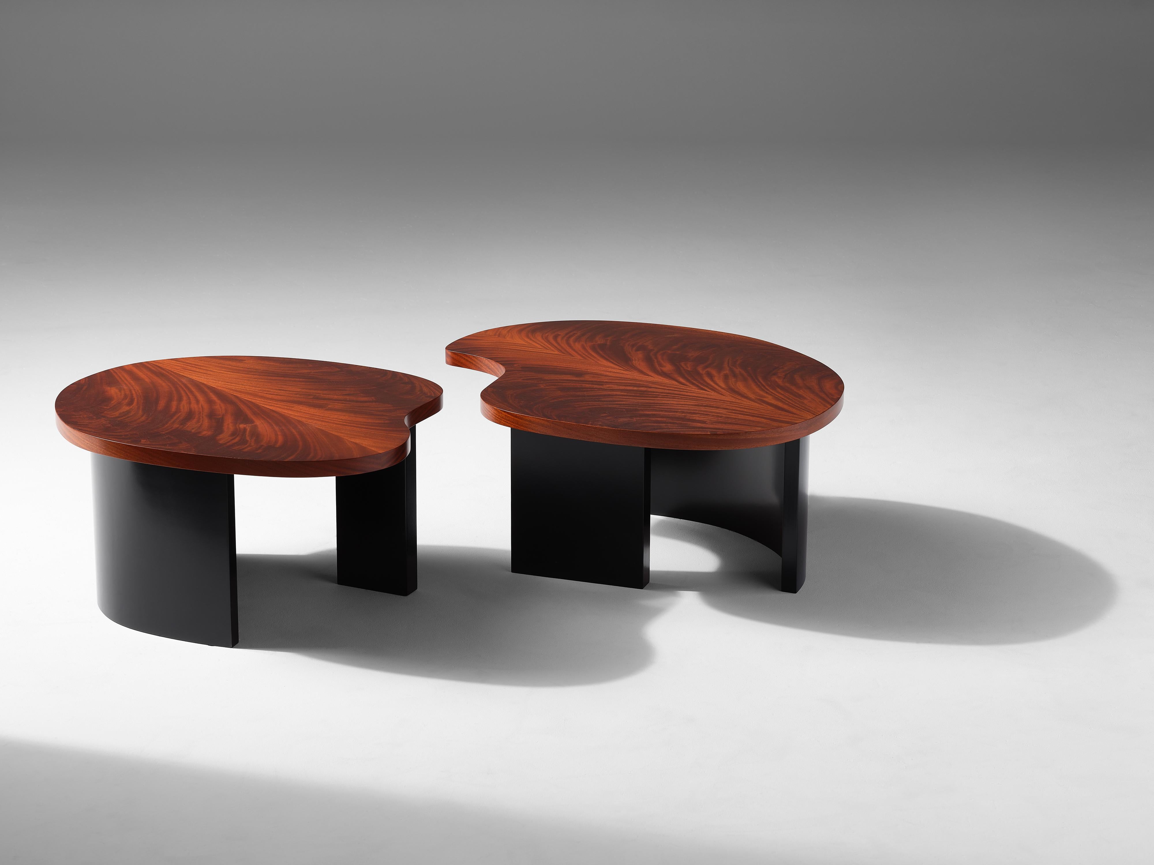 Douglas Fanning's unique bean table has an amorphous, polished mahogany top and rests upon curved, blackened steel legs. This beautifully abstract creation functions with an elegant simplicity befitting its form, pulling apart into two modular