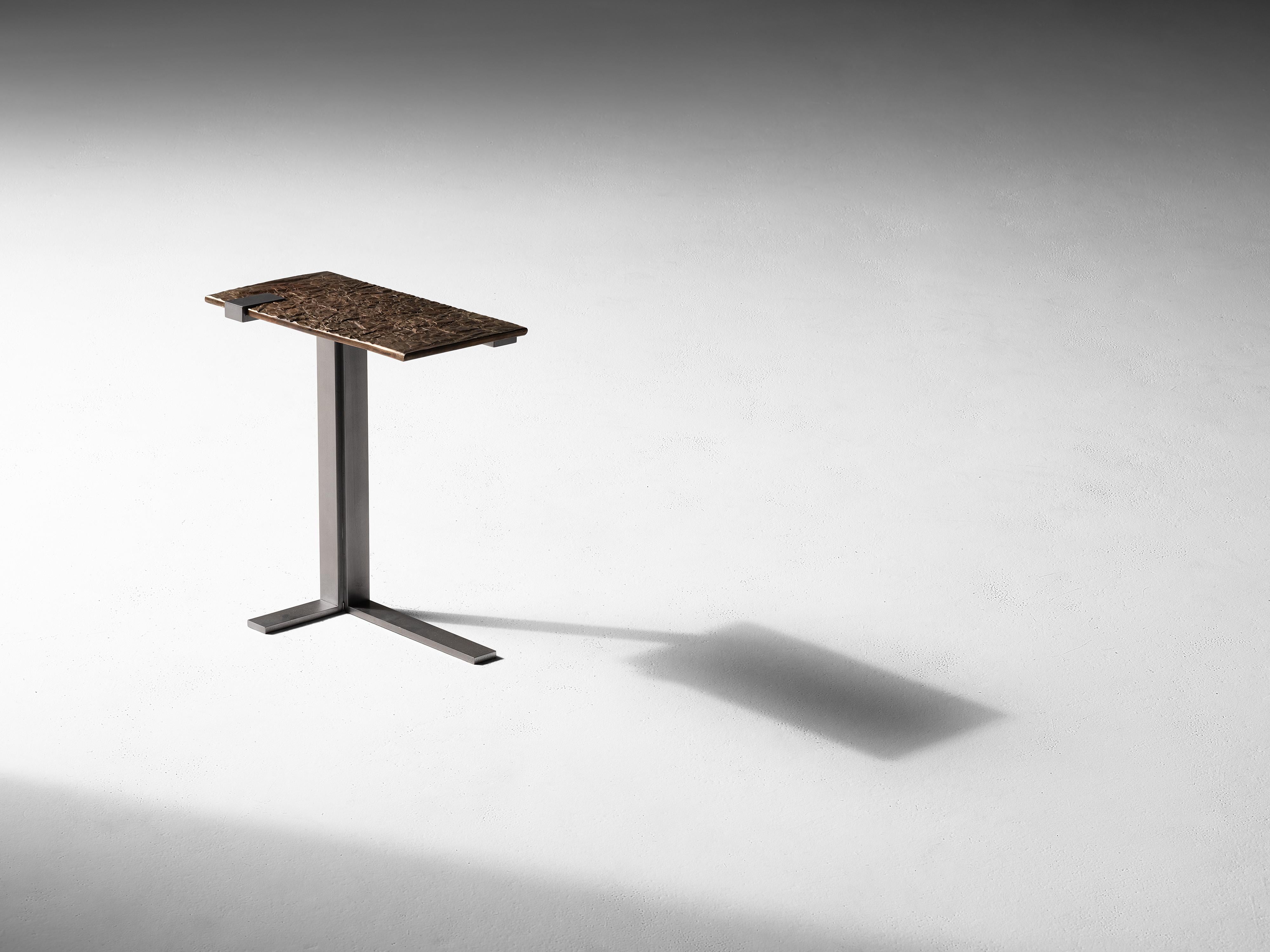 This geometric, cantilevered side table, an industrial arrangement of right angles in bronze and cold blackened steel, is adorned by a playful top reminiscent of a section of parched earth.

Master metalsmith Douglas Fanning's extra long console