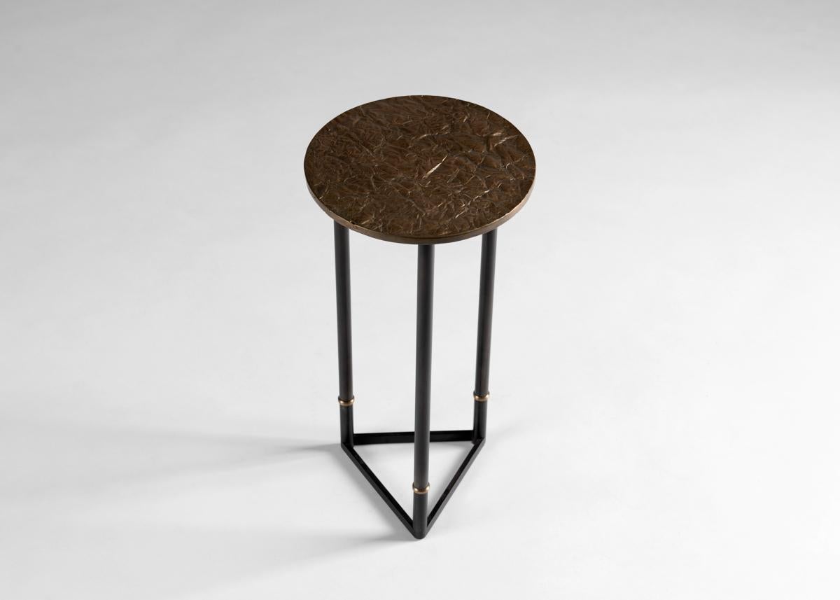 Created in collaboration with Nick Alan King.

This geometric side table, an Industrial arrangement of parallel lines and 60 degree angles in bronze and cold blackened steel, is adorned by a playful top reminiscent of a section of parched
