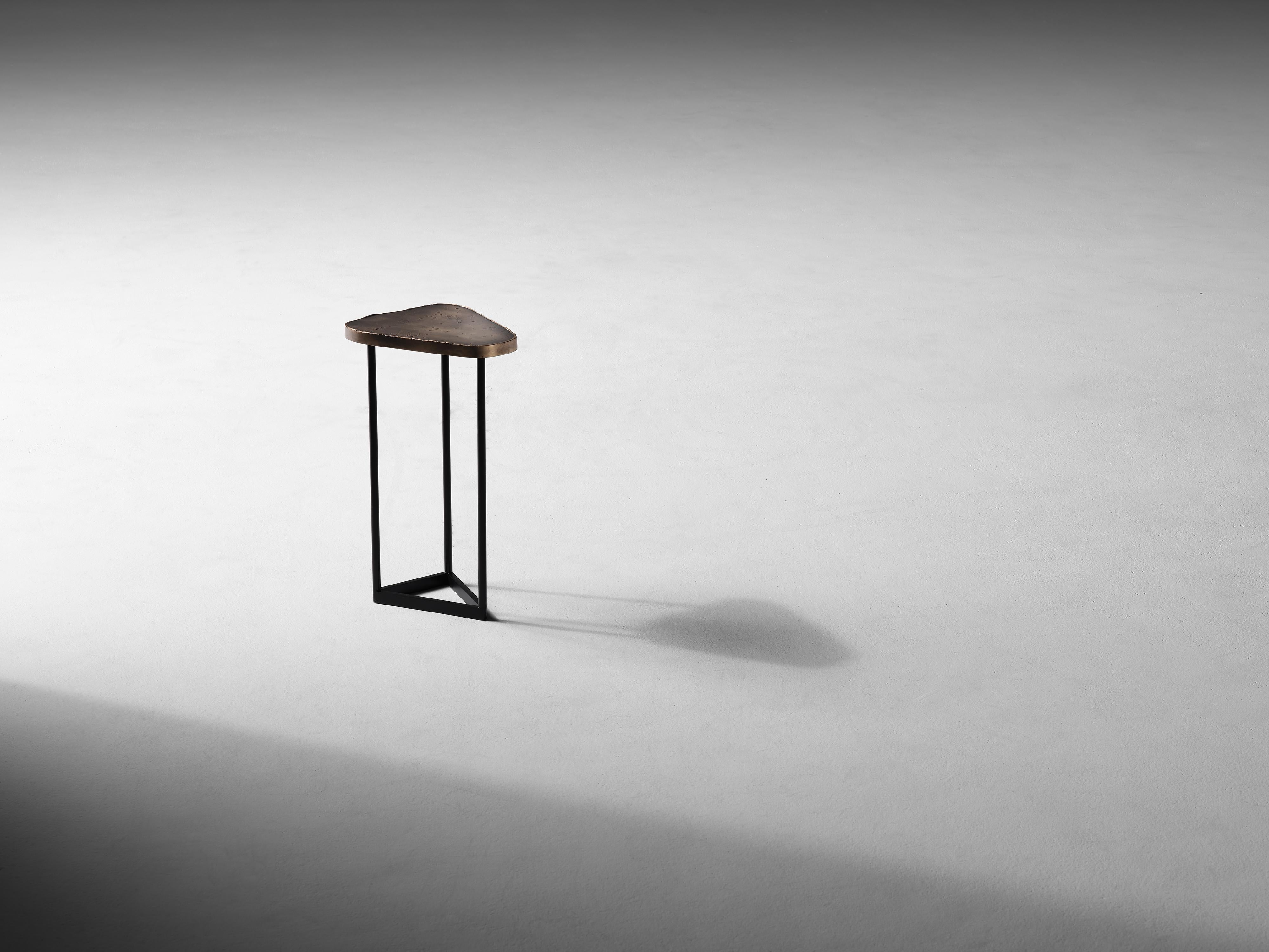 Created in collaboration with Nick Alan King.

This charming side table, an industrial arrangement of warm bronze and cold blackened steel, has a playfully amorphous top, a counterbalance to the rigid geometry of its legs and base.

Douglas Fanning