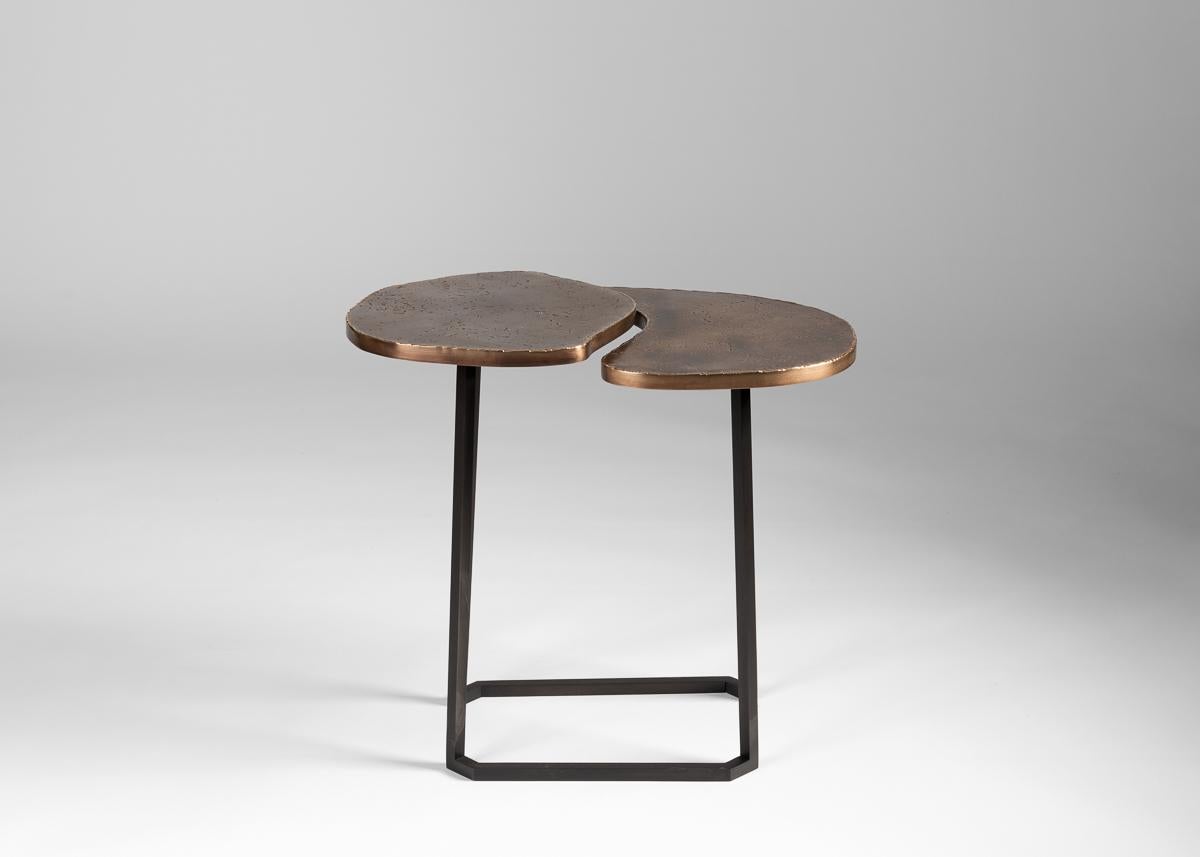 This set of conjoining tables, topped in dappled brass and supported by blackened steel legs, is not just a work of supreme craftsmanship, but of stunning elegance, its two surfaces separated by a subtle gap that gives them an unexpected