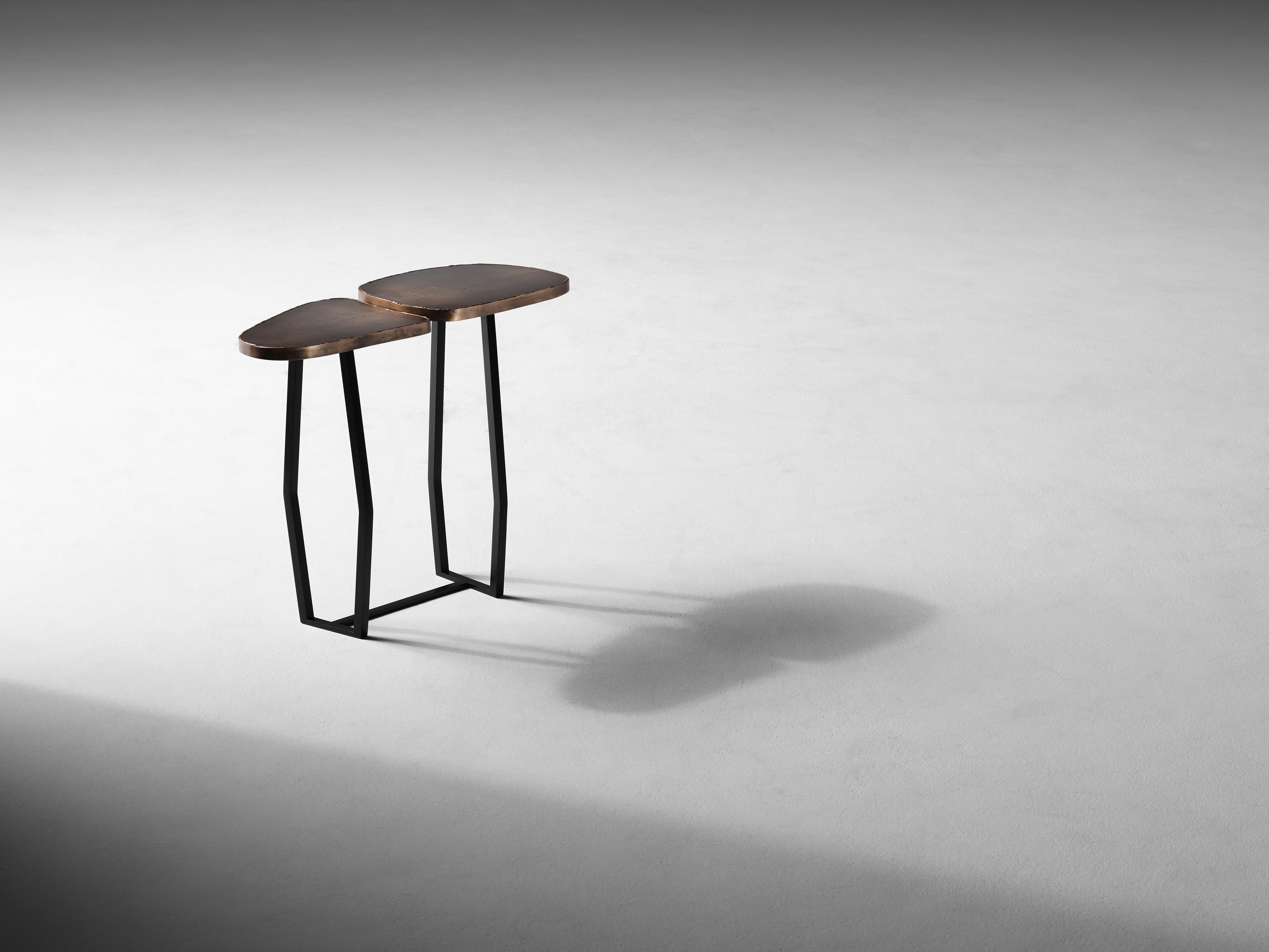 This set of conjoining tables, topped in dappled brass and supported by blackened steel legs, is not just a work of supreme craftsmanship, but of stunning elegance. With its two surfaces separated ever so slightly, the piece possesses a certain