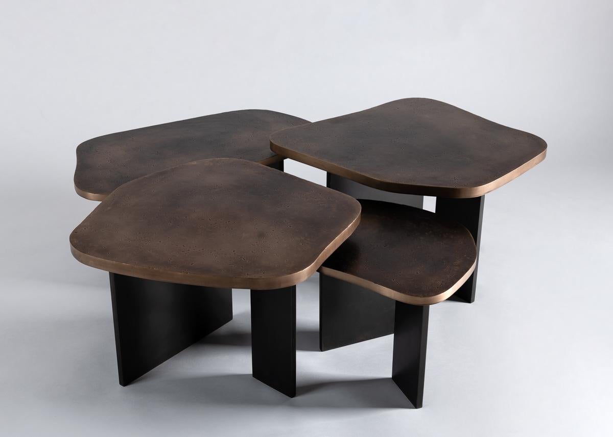 Douglas Fanning's remarkable nesting tables have amorphous, dappled bronze tops and rest upon legs of blackened steel. Considered as a whole, the beautifully abstract creation functions with an elegant simplicity befitting its form, working either