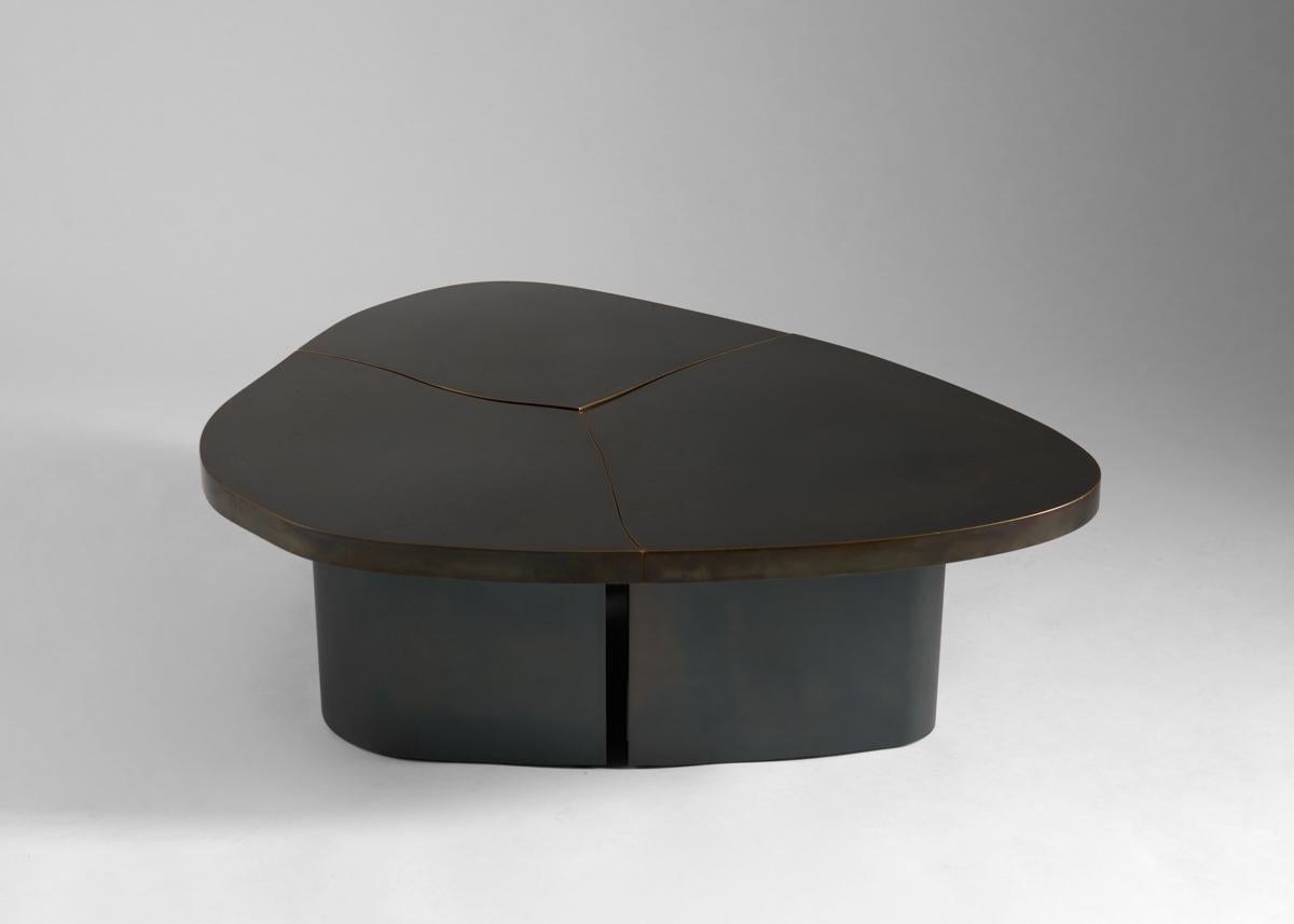 This beautiful coffee table, topped in a brooding bronze and supported by blackened steel legs, is not merely a work of supreme craftsmanship—this beautifully amorphous creation functions with an elegant simplicity befitting its form, pulling apart