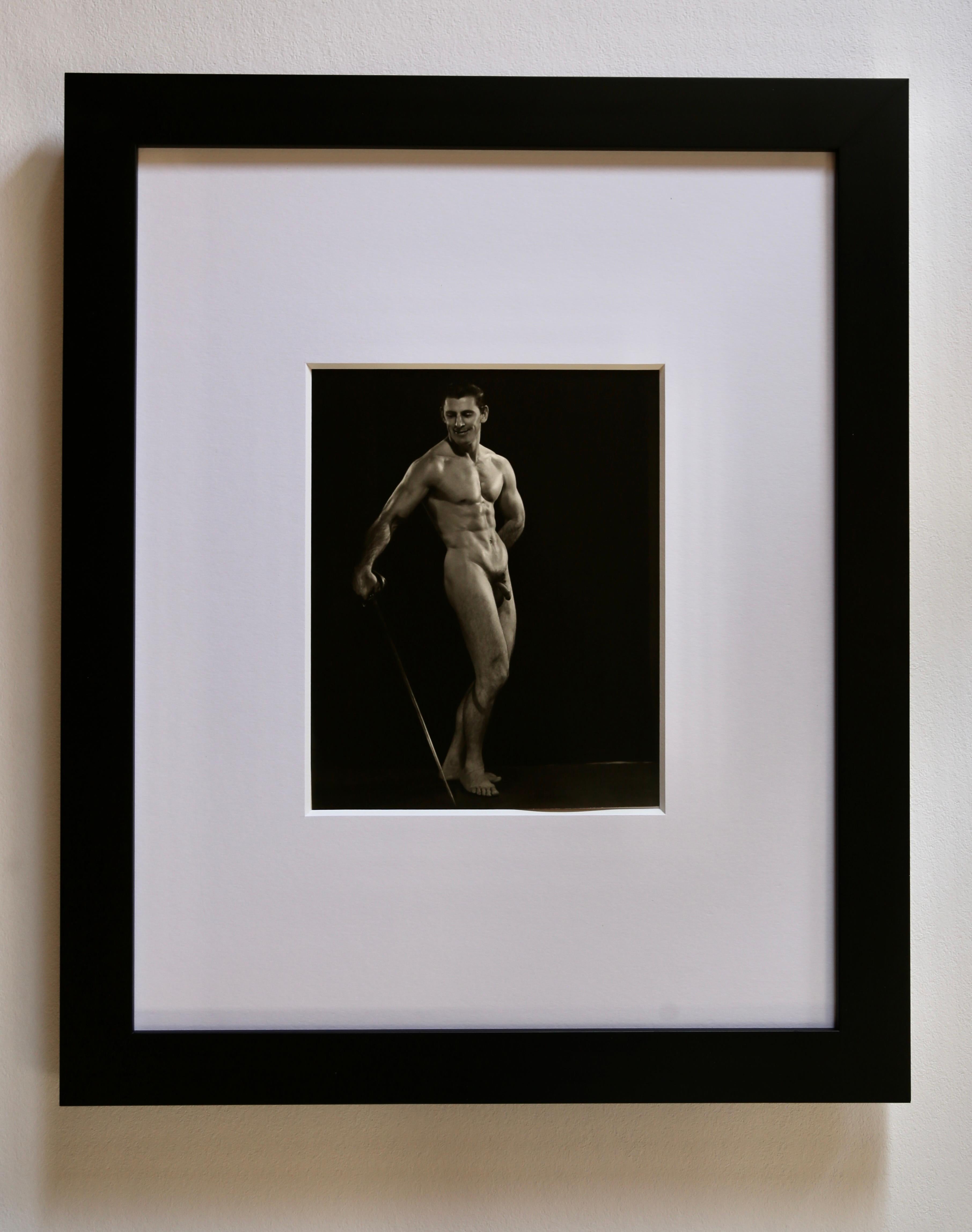 KALTER WINTER SUPER SPECIAL...$825...GERAHMT
Seltene 1940er Original Vintage Gelatine Silber Fotografie von DOUGLAS JULEFF - auch bekannt als DOUG OF DETROIT - von Bodybuilder und Mr. America Anwärter MIKE DUBEL posiert mit einem Schwert.  Dubel