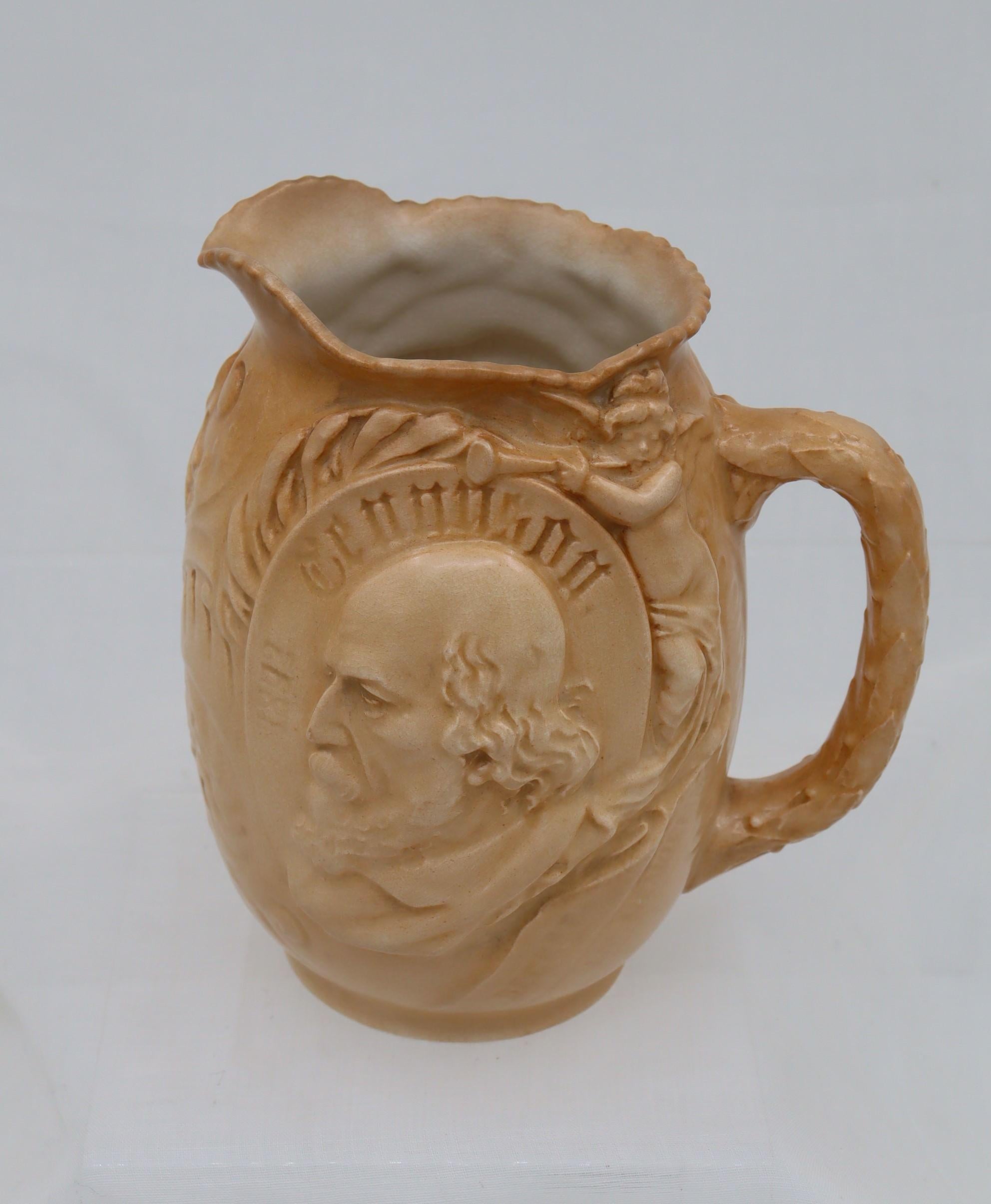 This Doulton Burslem commemorative jug was issued in 1892 to mark the death of Alfred, Lord Tennyson (1809-1892), who was the British Poet Laureate from 1850 until his death. On one side of the jug is a moulded semi-relief bust of the bare headed
