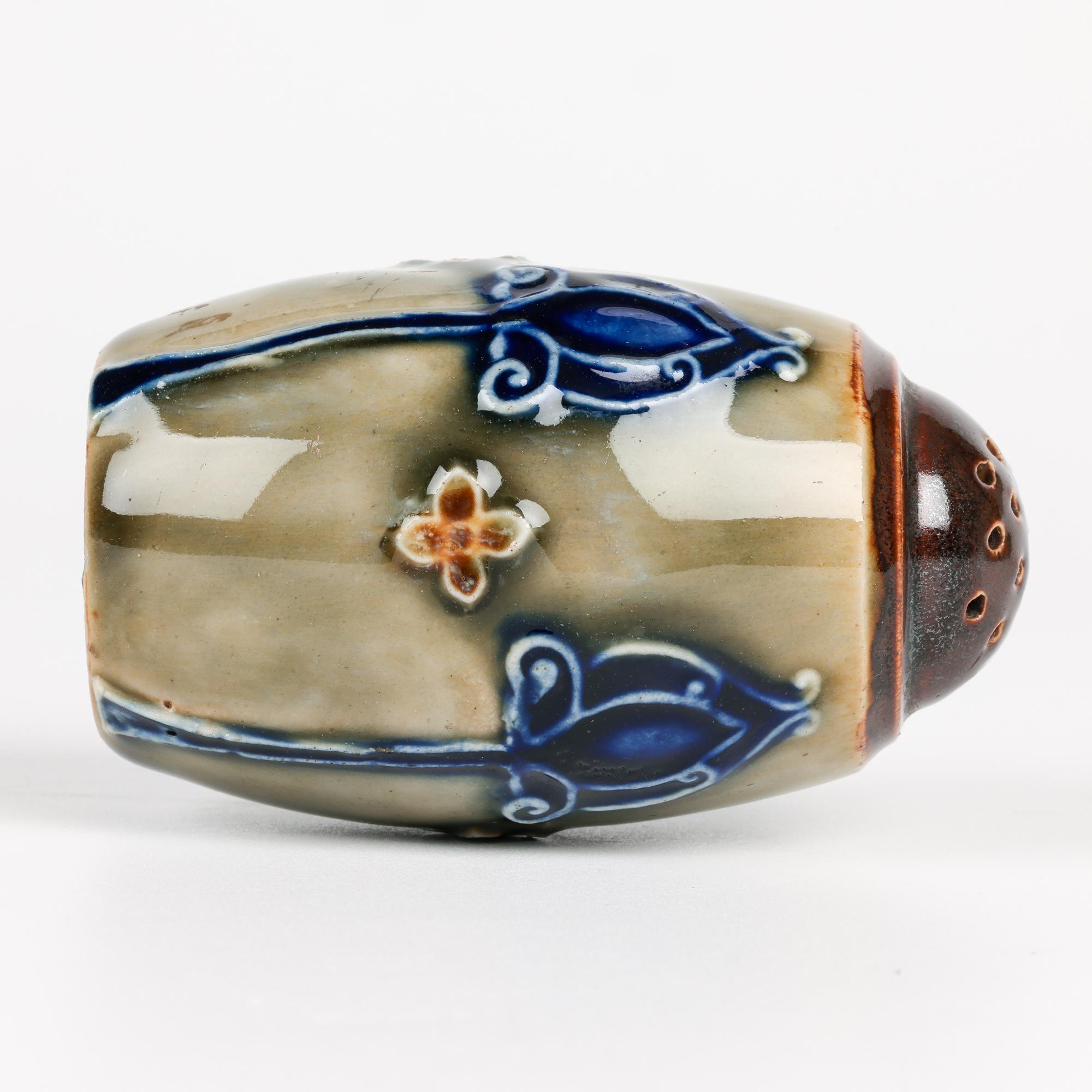 Une ravissante poivrière art nouveau Doulton Lambeth en poterie décorée de motifs floraux stylisés tubulaires réalisés par la célèbre artiste Lily Partington et datant d'environ 1902. La poivrière en grès est de forme simple et arrondie, reposant