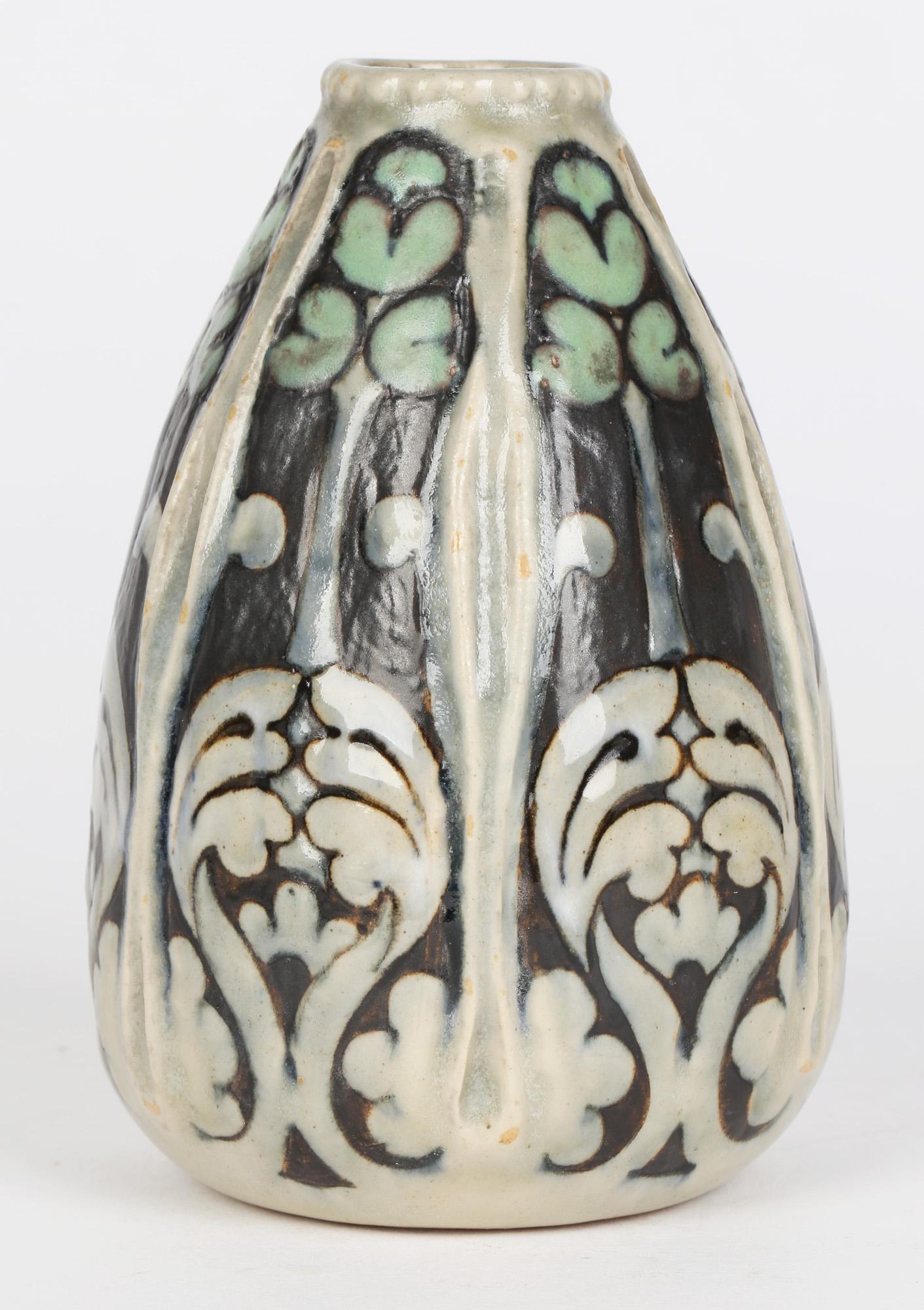 A stylish Doulton Lambeth art nouveau art pottery gourd shaped vase with stylized foliage in the Persian taste by Francis Pope and dating from around 1904. The vase is of rounded shape narrowing to a small rounded opening the body subdivided into