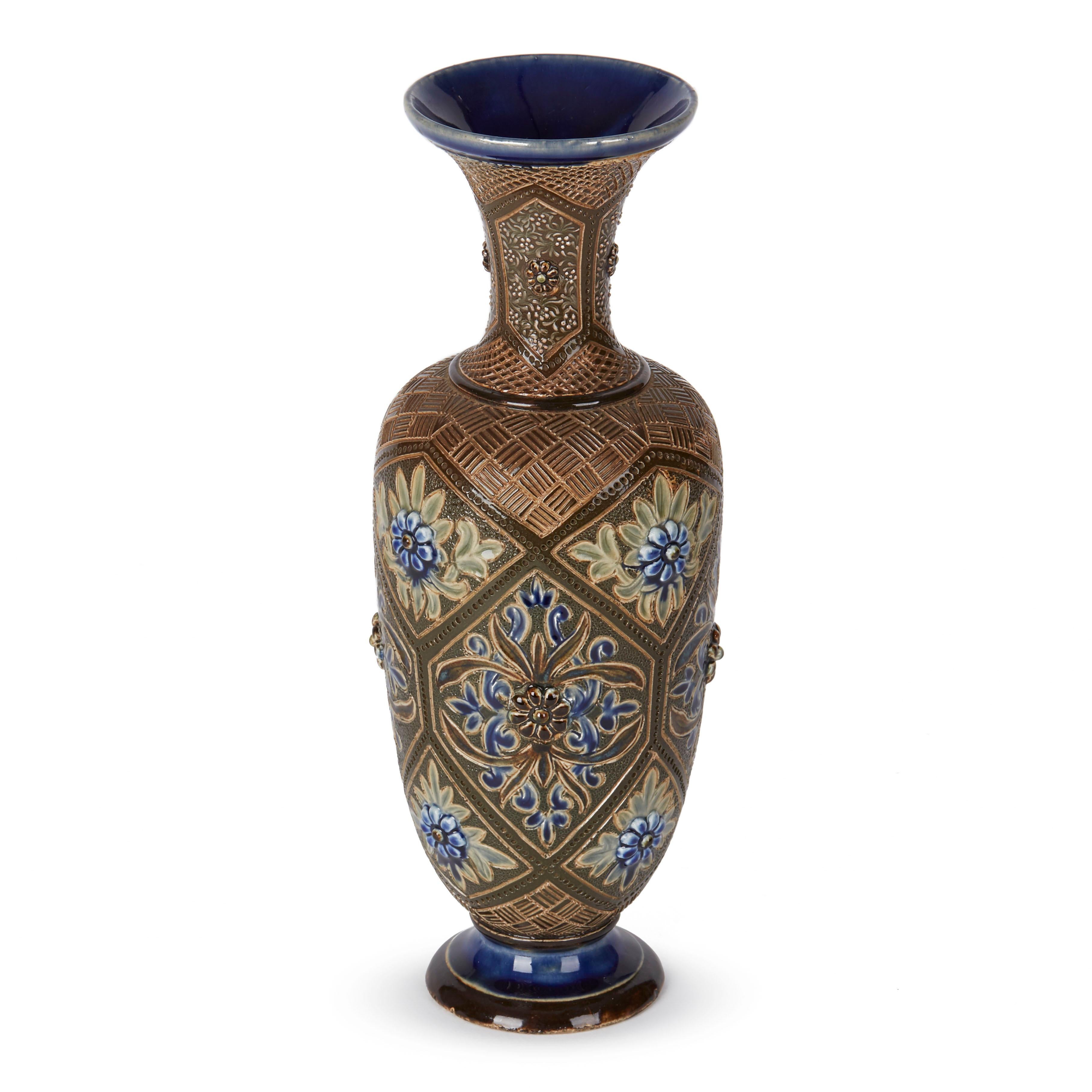 An exceptional and elegantly shaped Doutlon Lambeth art pottery stoneware vase of tall bulbous shape standing on a narrow rounded pedestal foot and with a trumpet shaped top by renowned artist Frank Butler. The vase is decorated with stylised